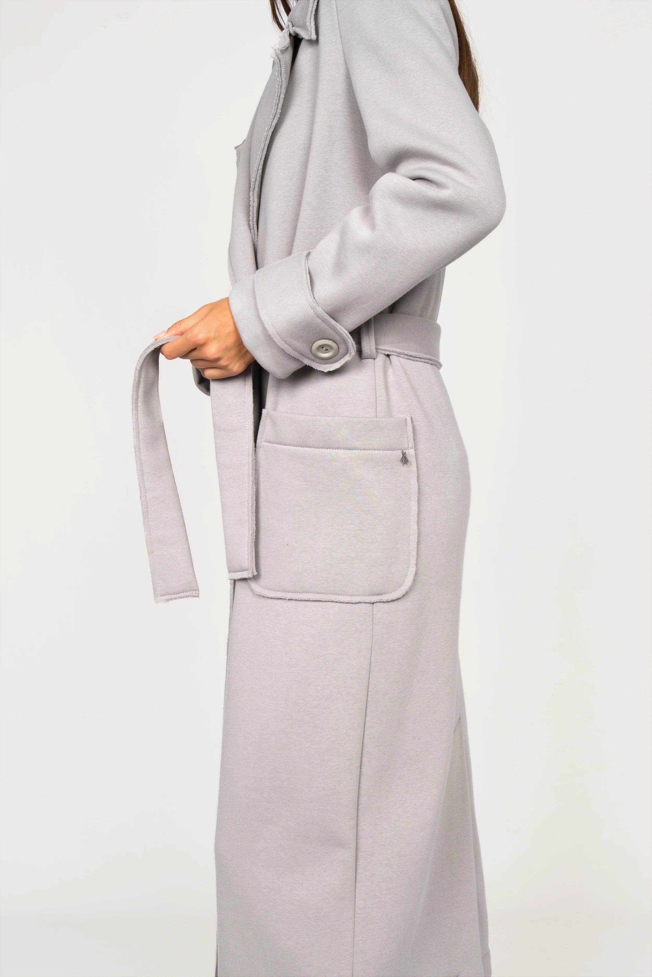 Seitliche Aufnahme des INGE Sweatmantels in Grau mit Bindegürtel und großer Tasche, weicher Baumwollqualität