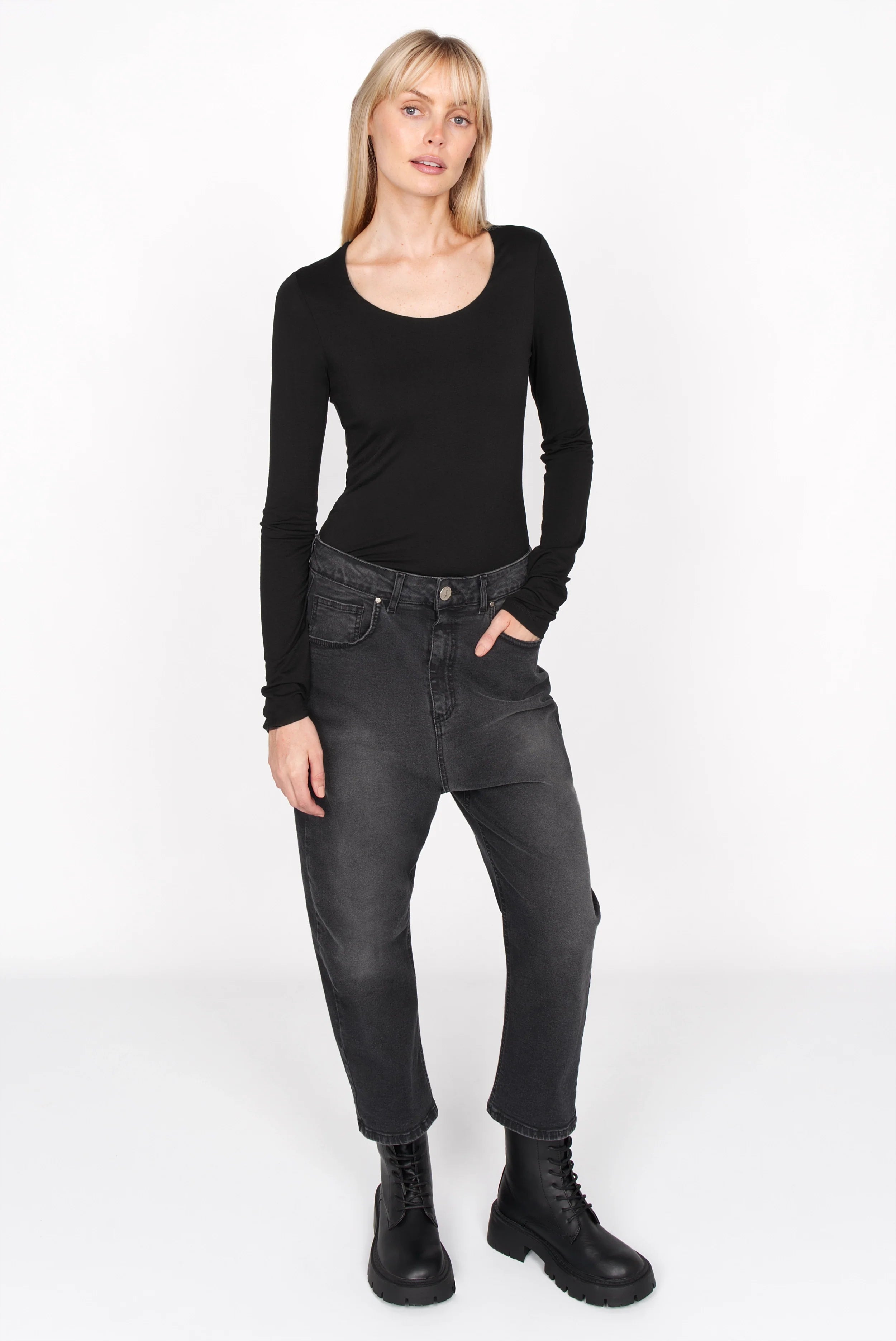 Schwarzes Longsleeve aus weichem Viskose-Jersey mit U-Boot-Ausschnitt und extra langen Ärmeln in Slim Fit getragen von Frau