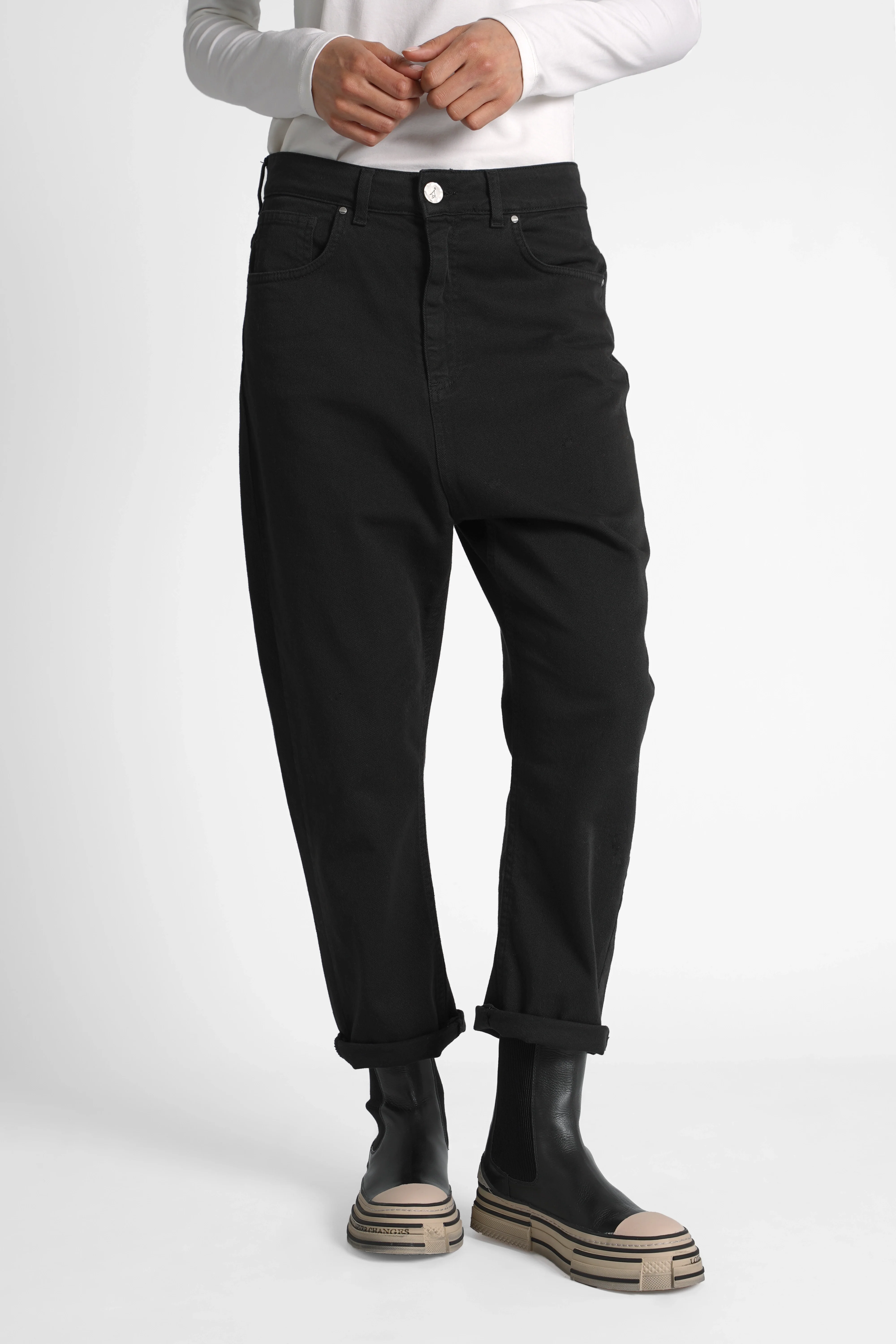 Black relaxed fit baggy jeans with deep crotch and cuffed legs modeled with white top and black boots