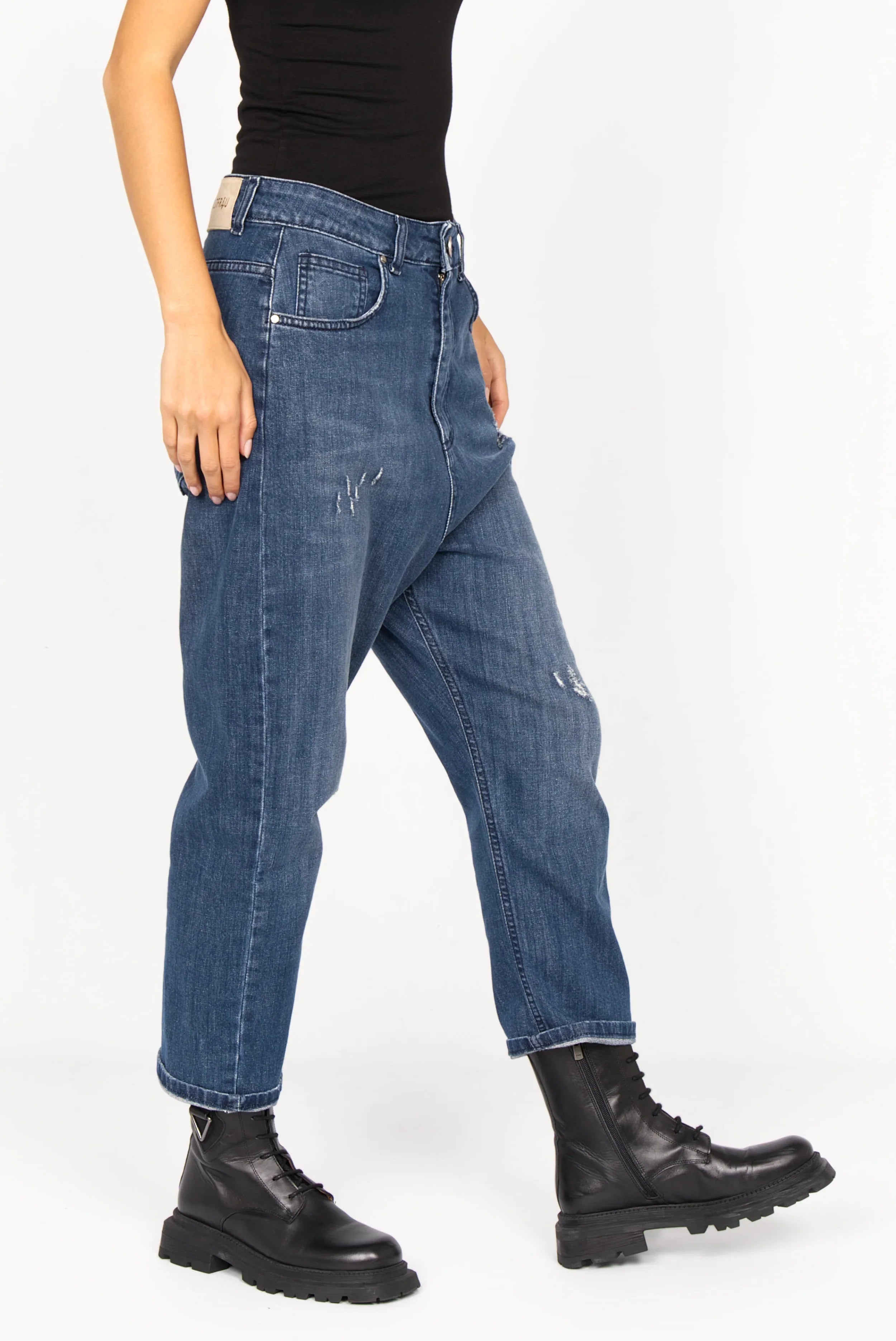 Medium blue baggy jeans with relaxed fit and subtle used effects worn with black boots