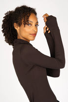 Frau trägt schwarzes KABEA Longsleeve mit Rollkragen und Daumenlöchern aus weicher Viskose, figurnah geschnitten