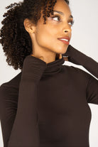 Frau trägt schwarzes KABEA Longsleeve mit Rollkragen und Daumenlöchern aus weicher Viskose