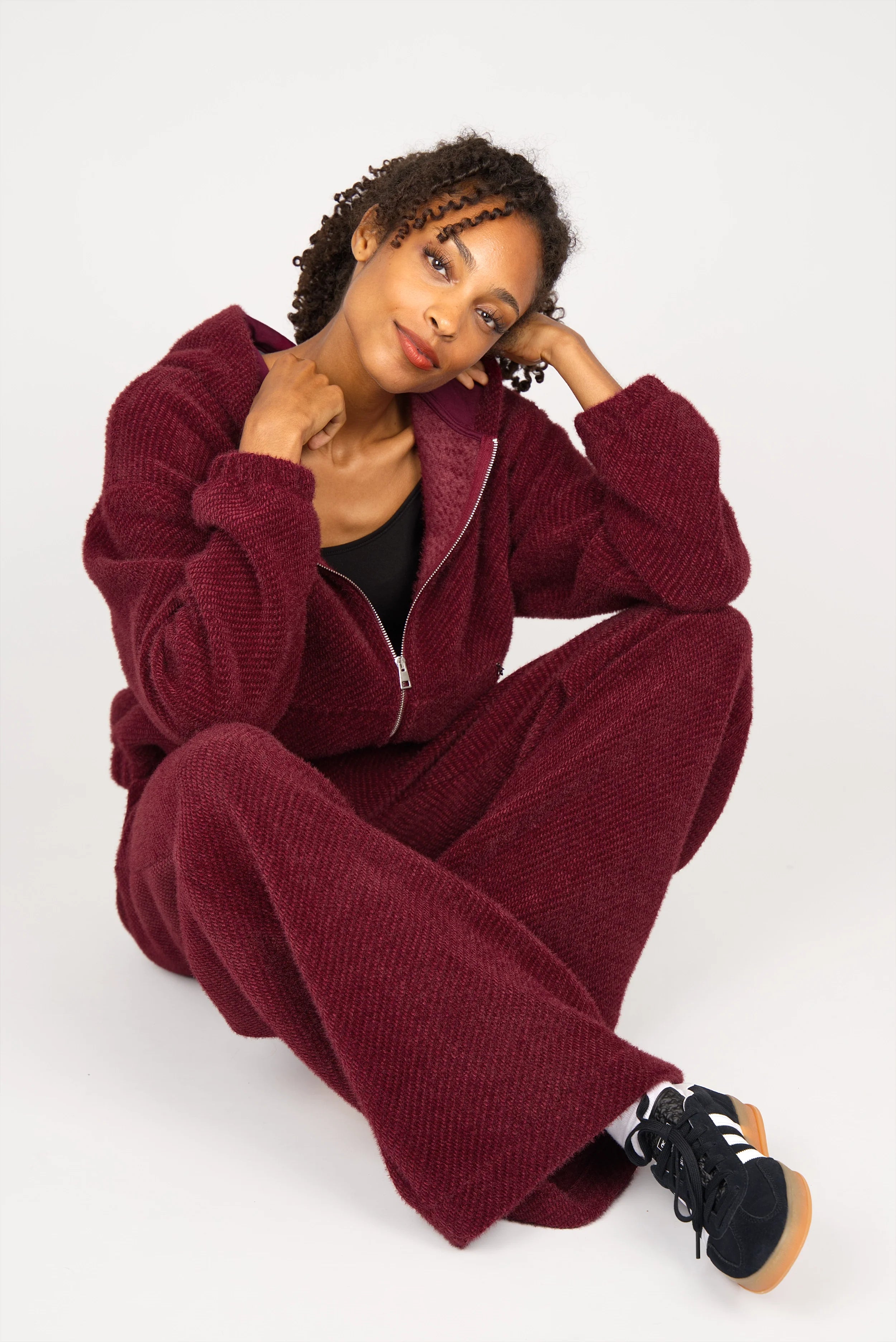 Frau in KELYA Wide Leg Hose aus samtig-weichem Kurzhaarfell in Burgunderrot im Relaxed Fit mit elastischem Bund und seitlichen Taschen