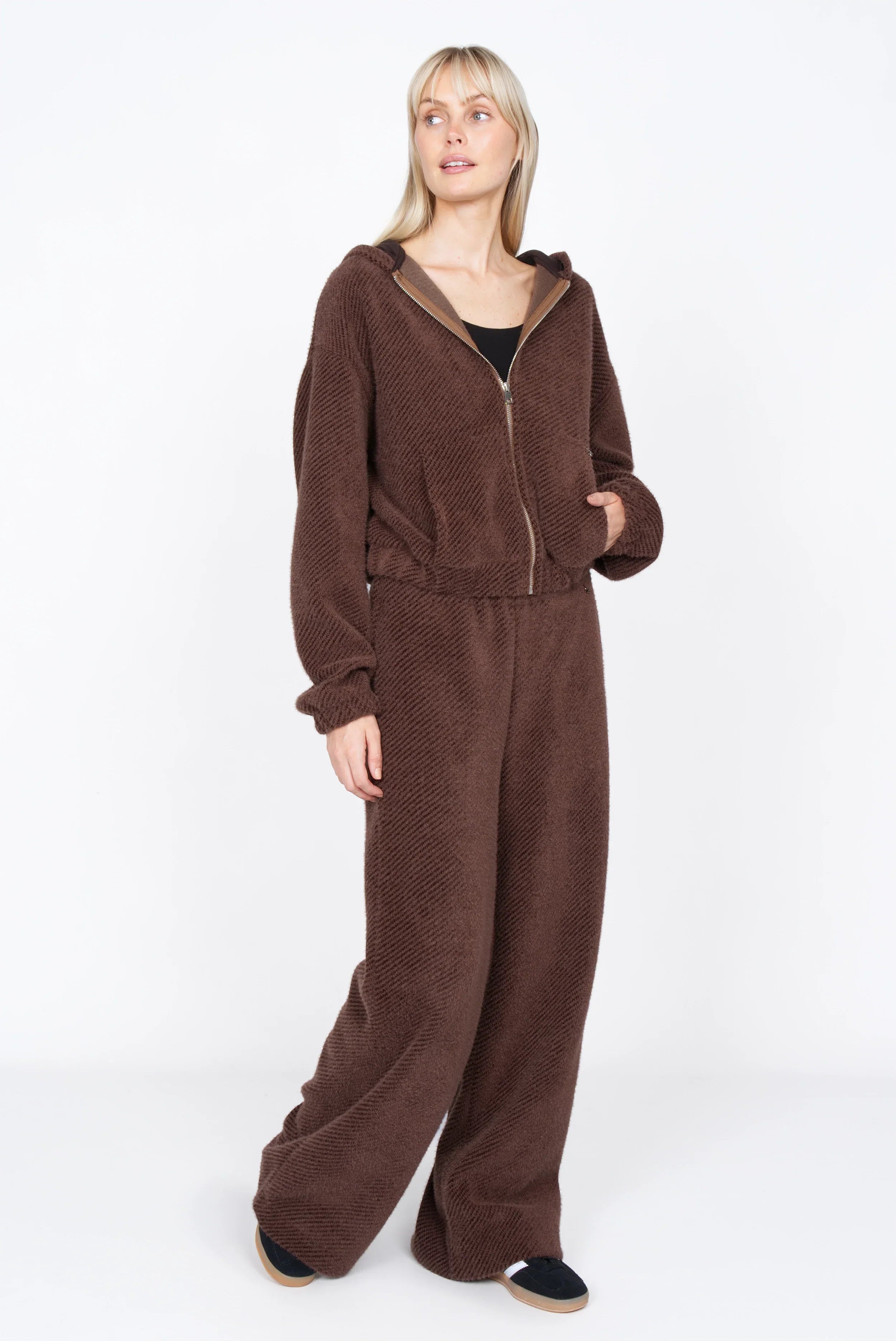 Model wearing KELYA Wide Leg Hose in relaxed fit with elastic waistband and side pockets in brown textured fabric