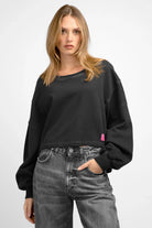 KERY Cropped Sweater in oversized fit with cold-washed cotton, U-boat neckline, dropped shoulders, pink logo patch, and longer back hem.
