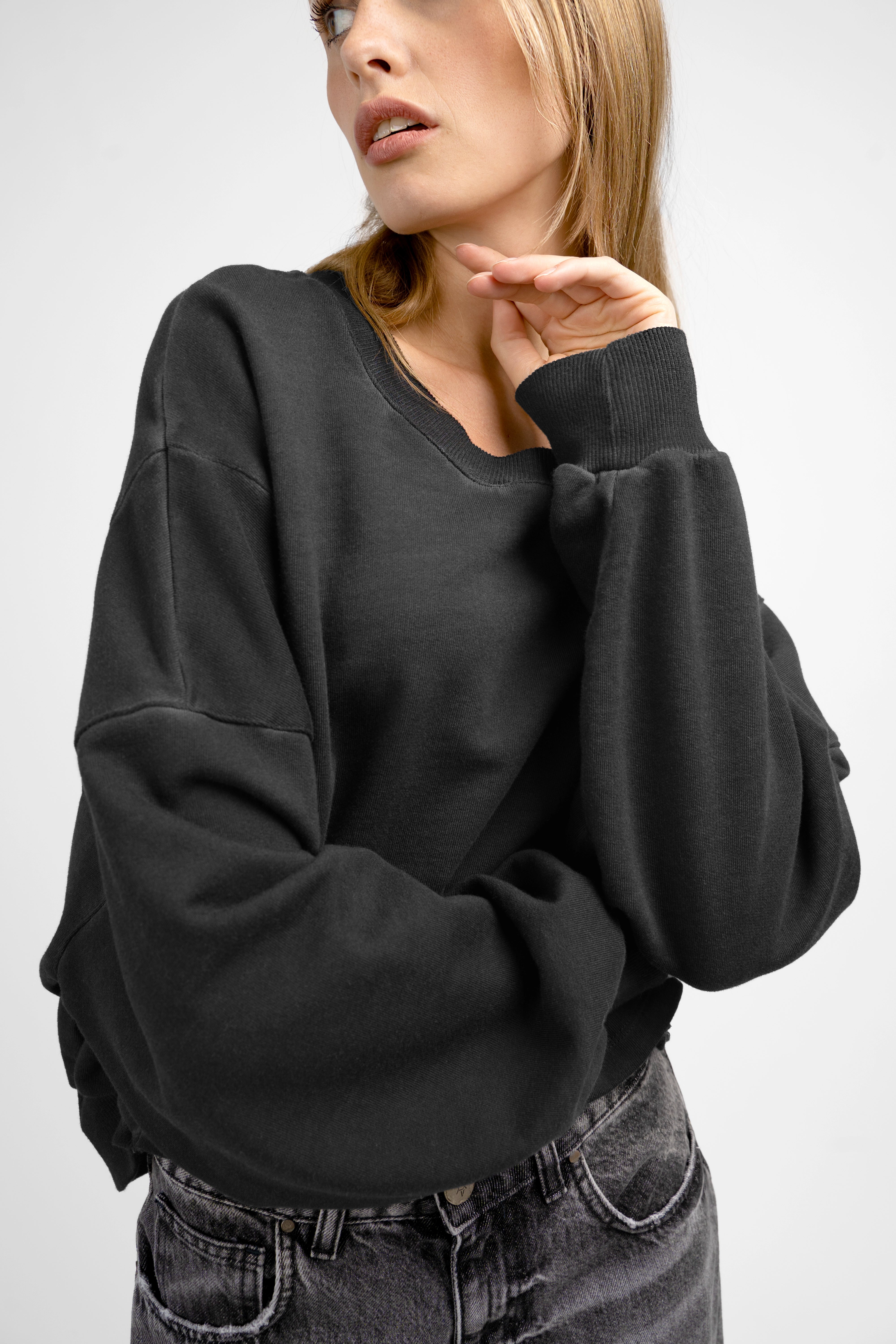Woman wearing black KERY Cropped Sweater with oversized fit and U-boat neckline