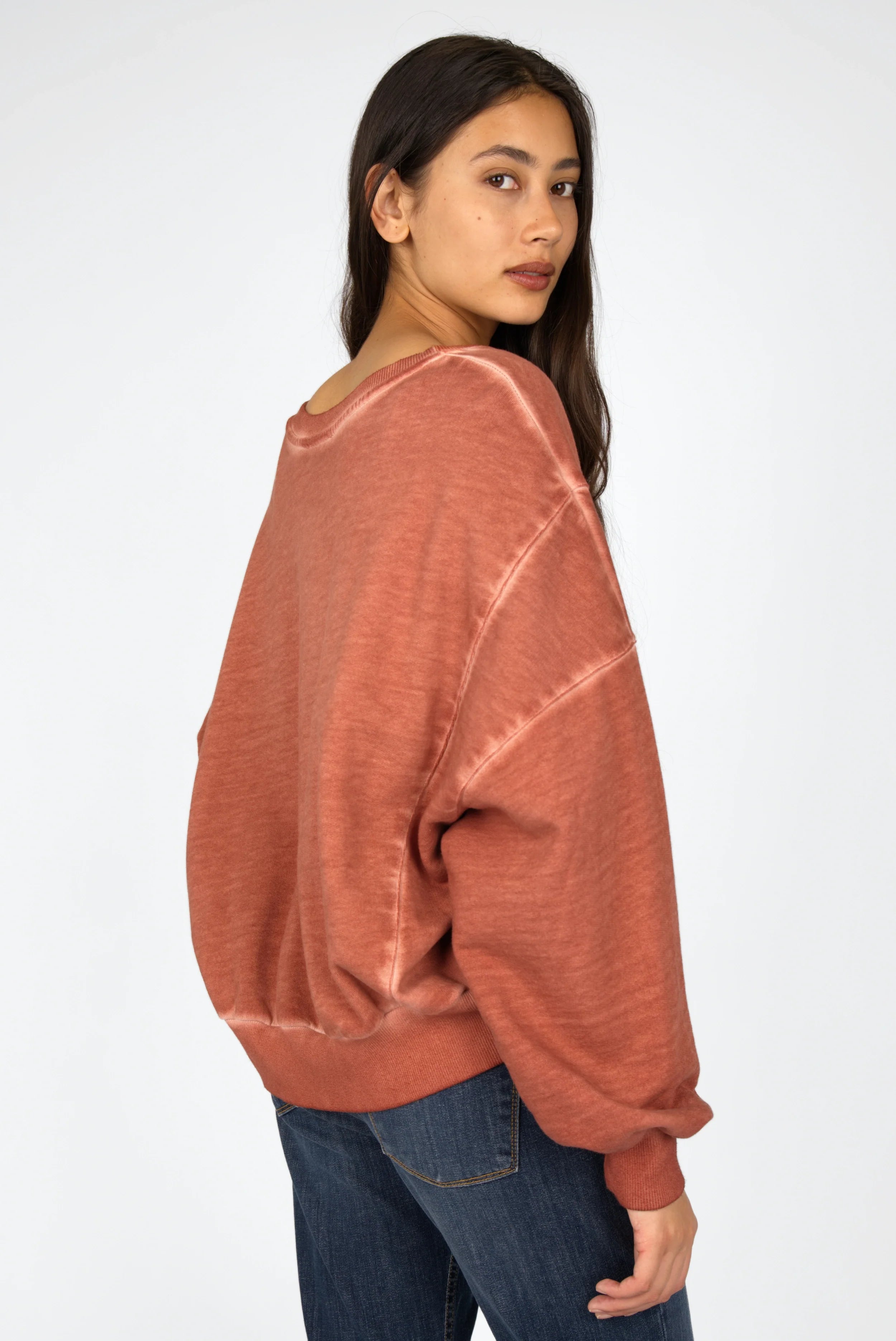 Damenmodell trägt KERY Cropped Sweater in oversized Fit mit U-Boot-Ausschnitt und cold-wash Baumwoll-Sweat in lachsfarben