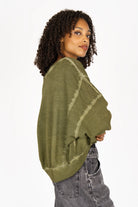 Model wearing olive green KERY Cropped Sweater with oversized fit, U-boat neckline, and dropped shoulders from the STUDIO Edition.
