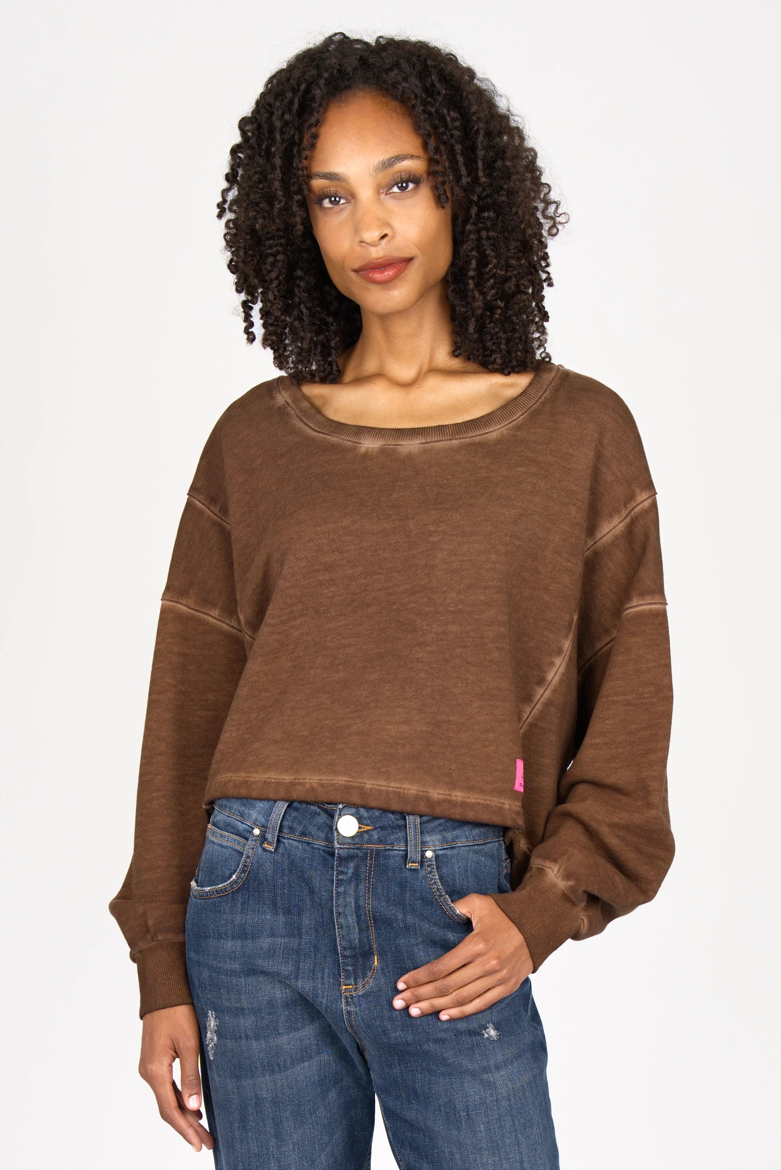 Frau trägt braunen KERY Cropped Sweater mit U-Boot-Ausschnitt, oversized Passform und überschnittenen Schultern