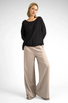 Damen trägt beige KLARA.K Wide Leg Pants aus softem Heavy Viscose-Mix mit weitem Bein und elastischem Bund