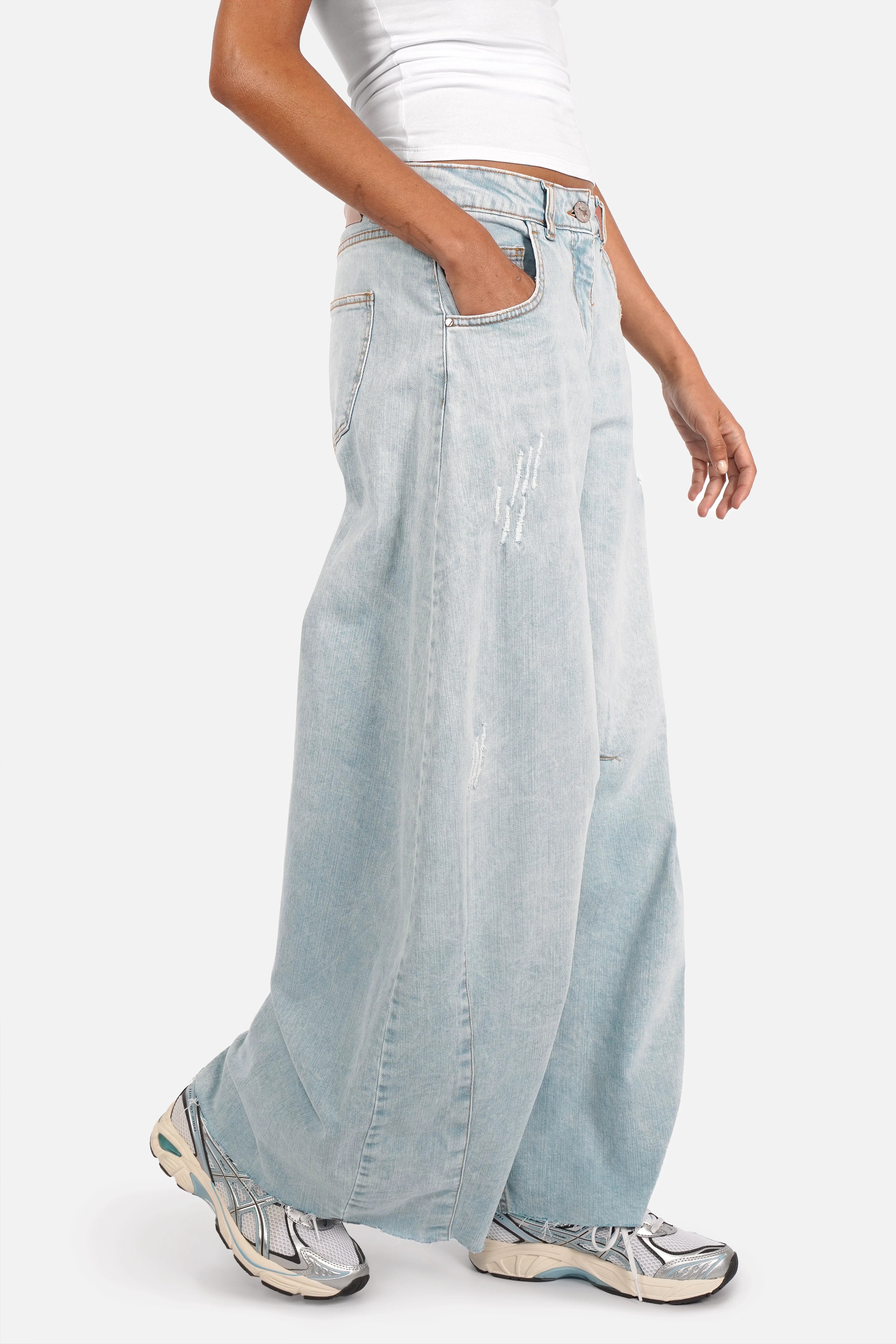 Lightweight Italian denim weite Barrel Jeans with bleached blue wash, subtle destroyed details, raw-cut hem, and relaxed fit