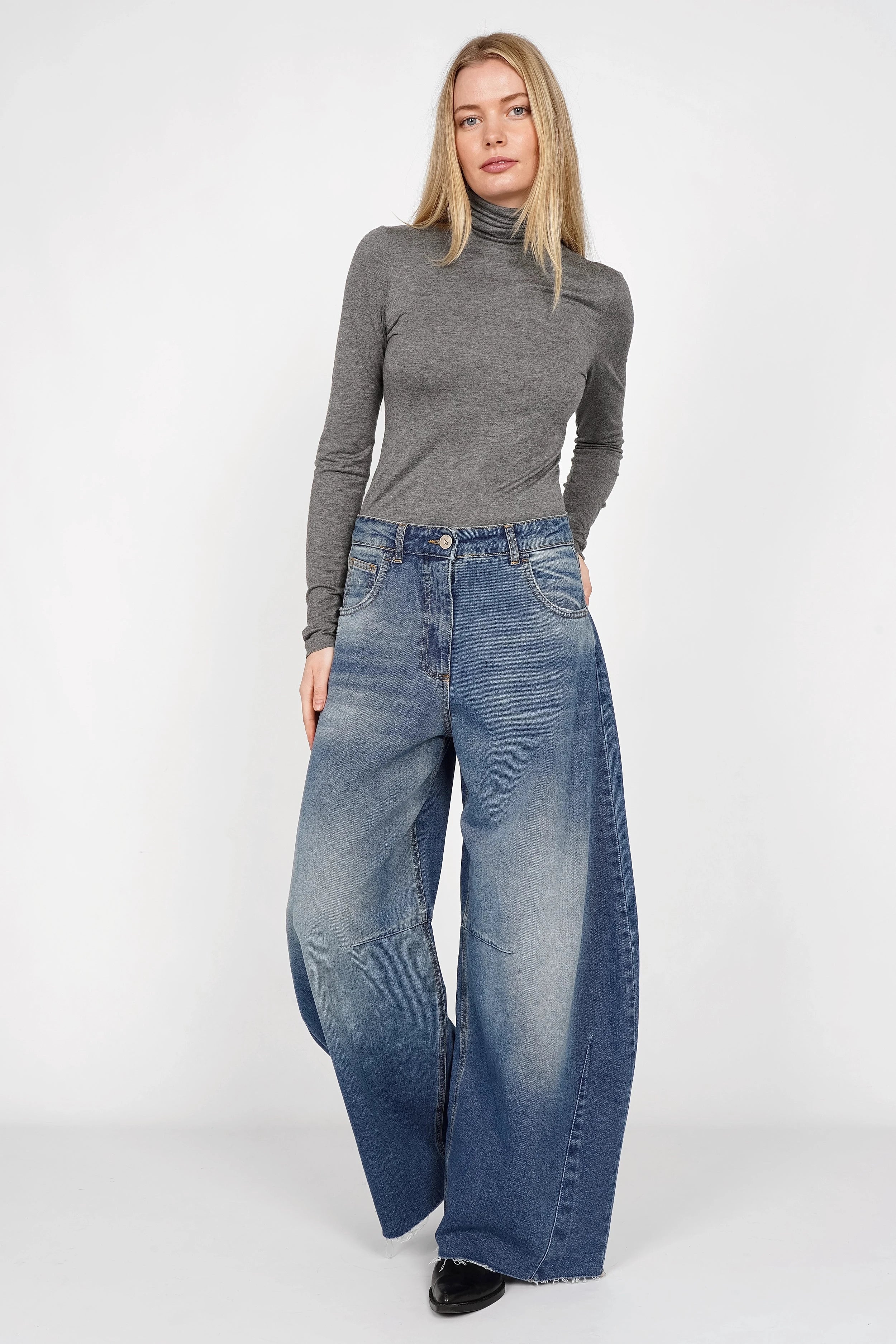 Frau trägt weite Barrel Jeans mit hoher Taille, leichtem Whisker-Effekt und Raw-Cut Saum