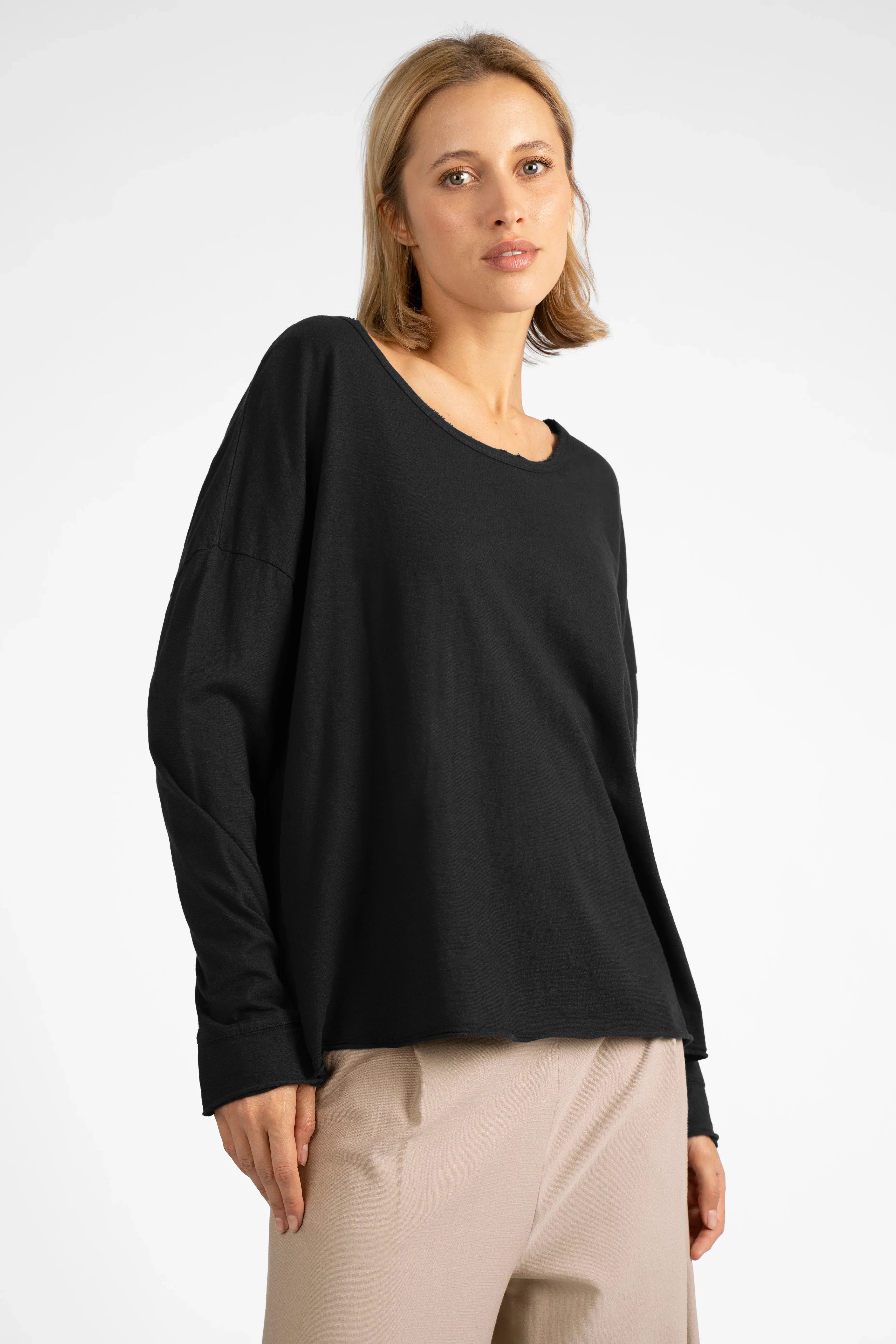 Woman wearing black LARXA Longsleeve in soft fiammato cotton with round neck and open edge cuffs