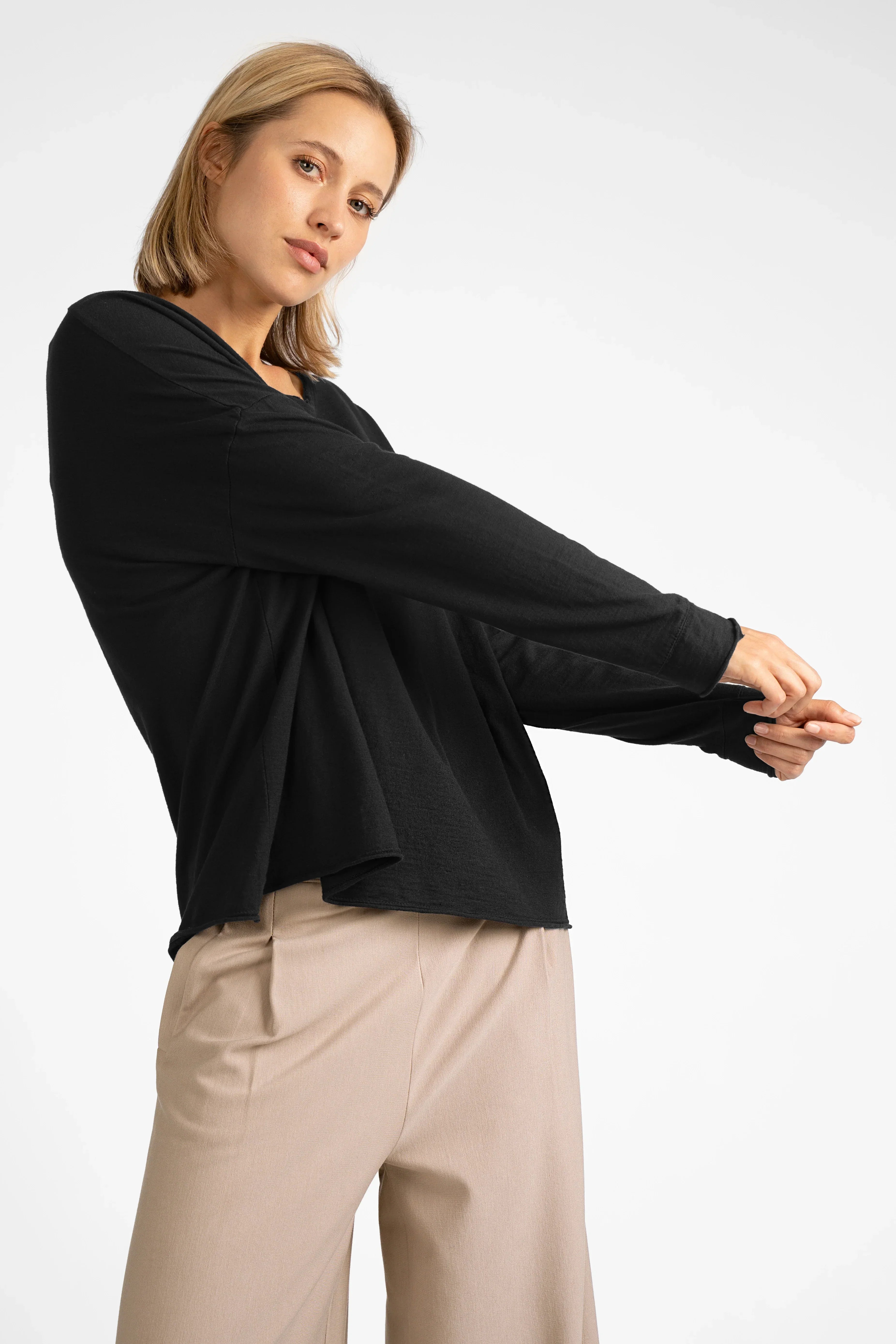Woman wearing black LARXA Longsleeve made of soft Fiammato cotton with round neckline and open edges
