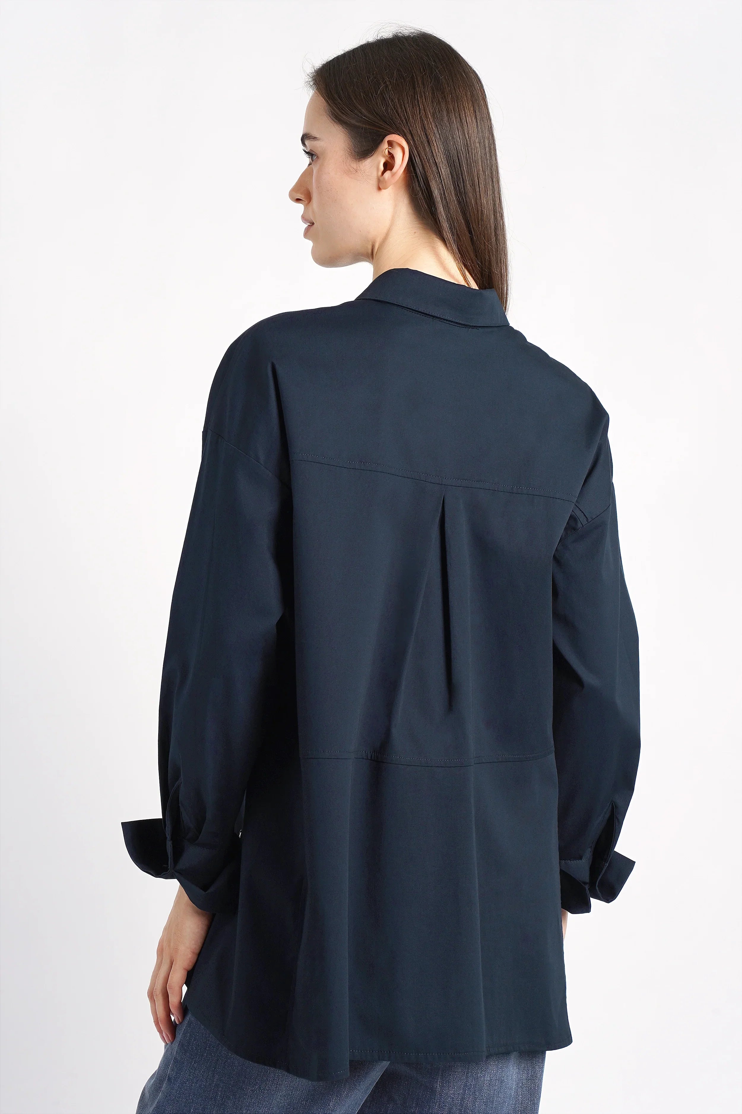 Frau trägt LEA.K Loose Fit Bluse aus Baumwollpopeline, locker geschnitten, dunkelblau, mit Rückenfalte und verlängertem Rückenteil.
