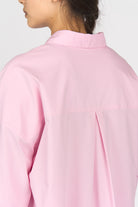 Back view of a pink LEA.K Loose Fit blouse with a loose fit, trapezoidal longer back, and pleat detail under the yoke.