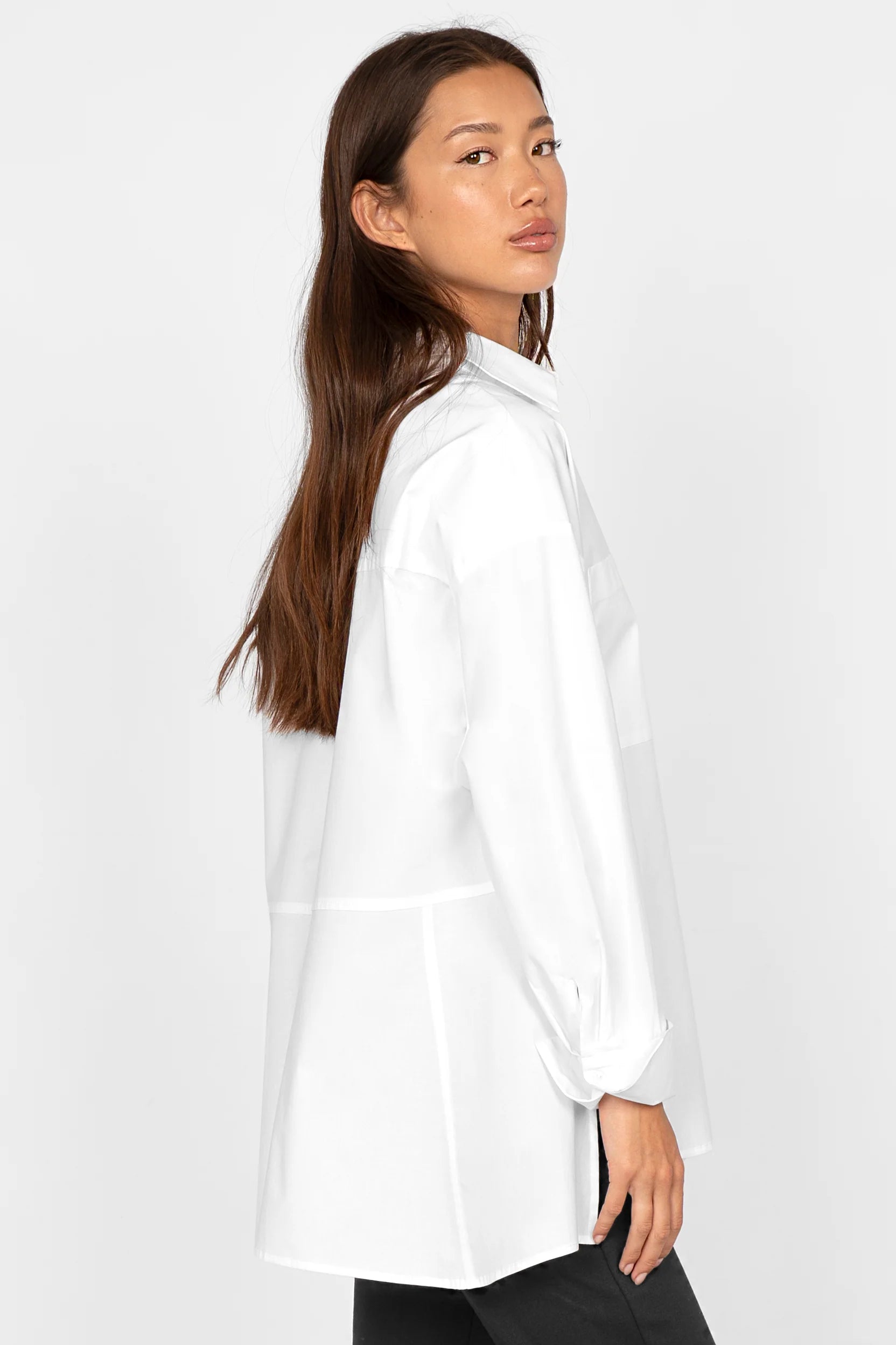 White LEA.K Loose Fit blouse with shirt collar and long sleeves, featuring a trapezoid back and deep side slits.