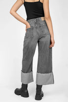 Back view of a person wearing LIAME Cropped Jeans with raw-cut cuff and whisker effect in relaxed fit.