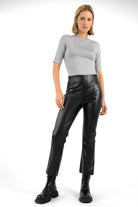 Woman wearing LIMGARD Flared Eco-Lederhose black high-waist cropped leather pants with flared leg and elastic waistband