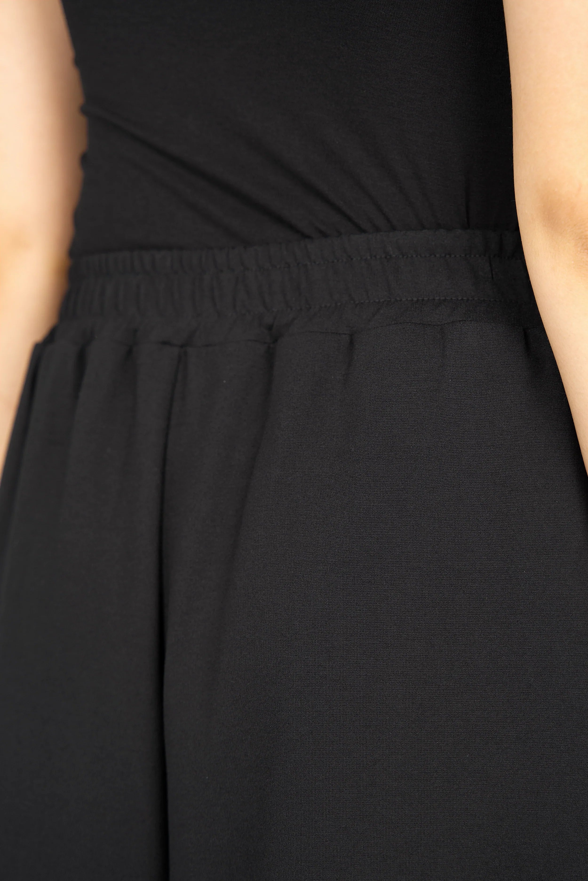 Close-up of the elastic waistband on the black LINNEE Wide-Leg-Hose made from soft interlock fabric with relaxed fit and side pockets.