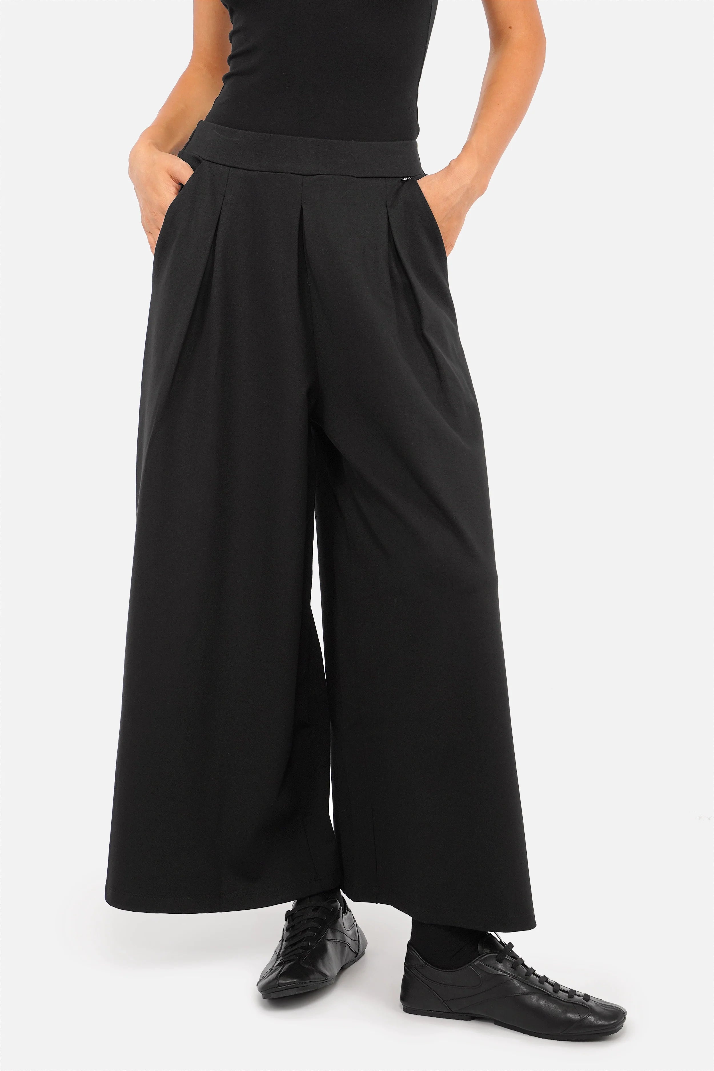 Damen trägt LINNEE Wide Leg Hose aus fließender Interlock-Qualität mit weitem Bein und elastischem Bund