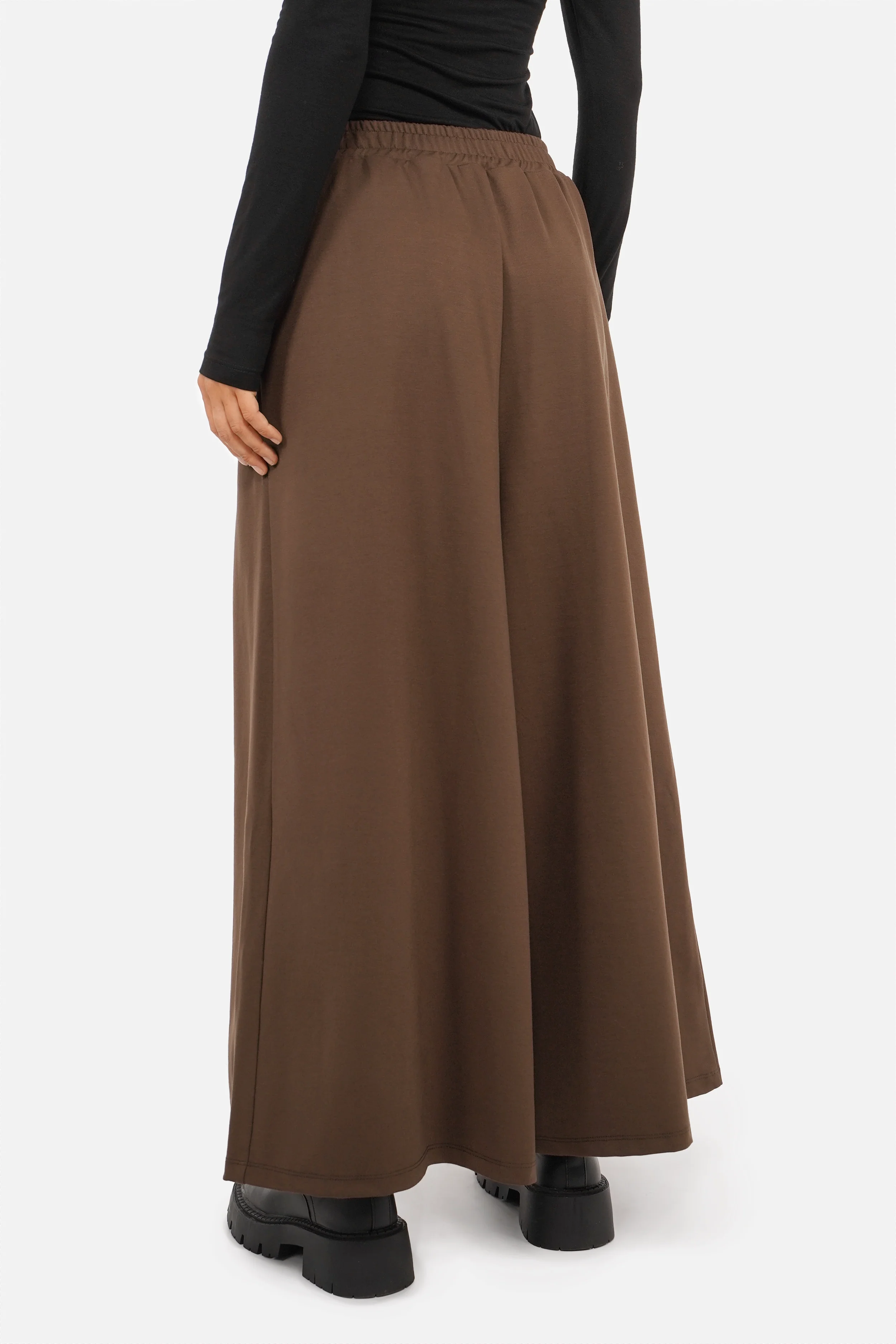 Frau trägt LINNEE Wide-Leg-Hose aus fließender Interlock-Qualität mit weitem Bein und elastischem Bund