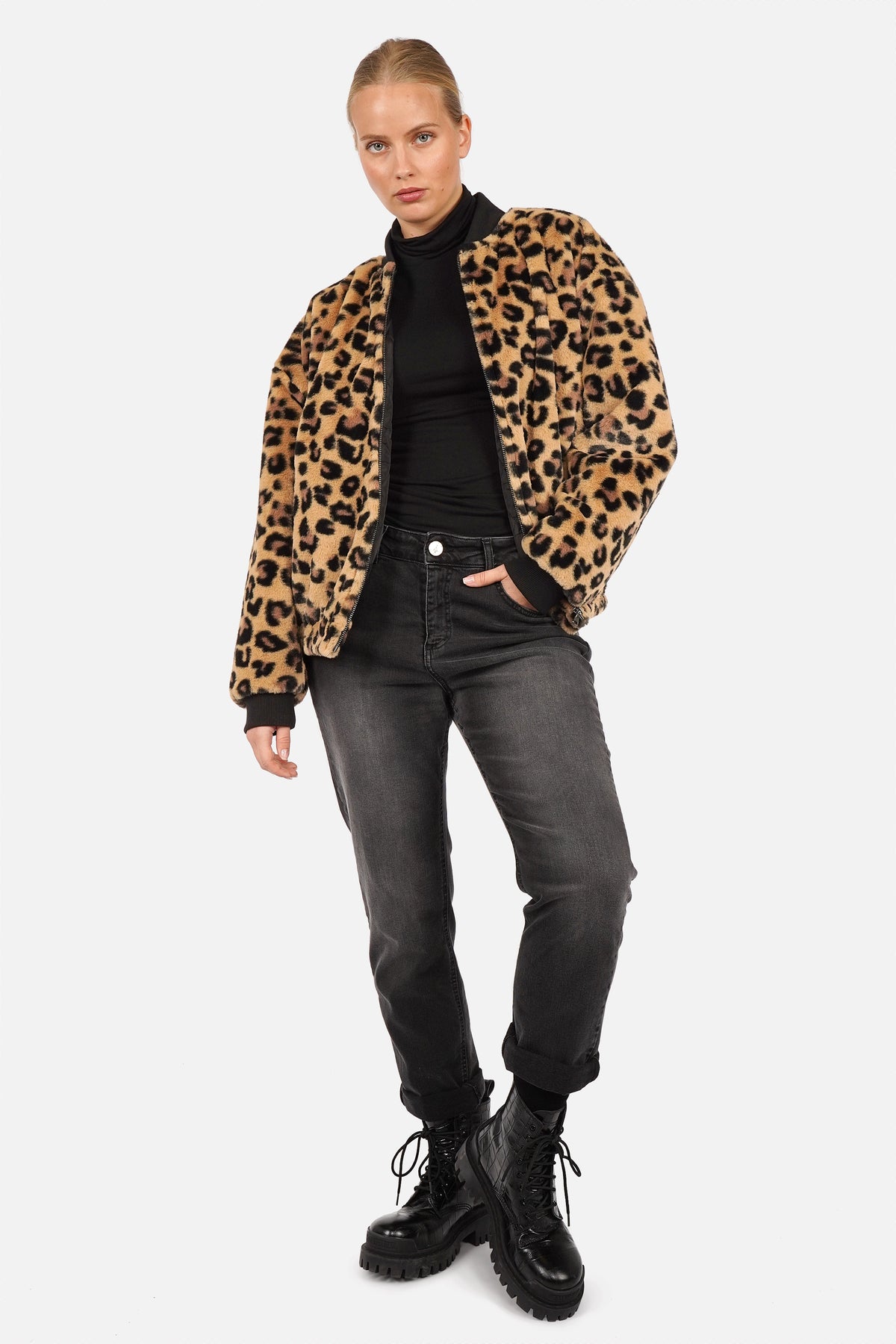 LIORA Kunstpelz-Bomberjacke mit Leopardenmuster, offen getragen zu schwarzem Rollkragenoberteil und grauer Jeans
