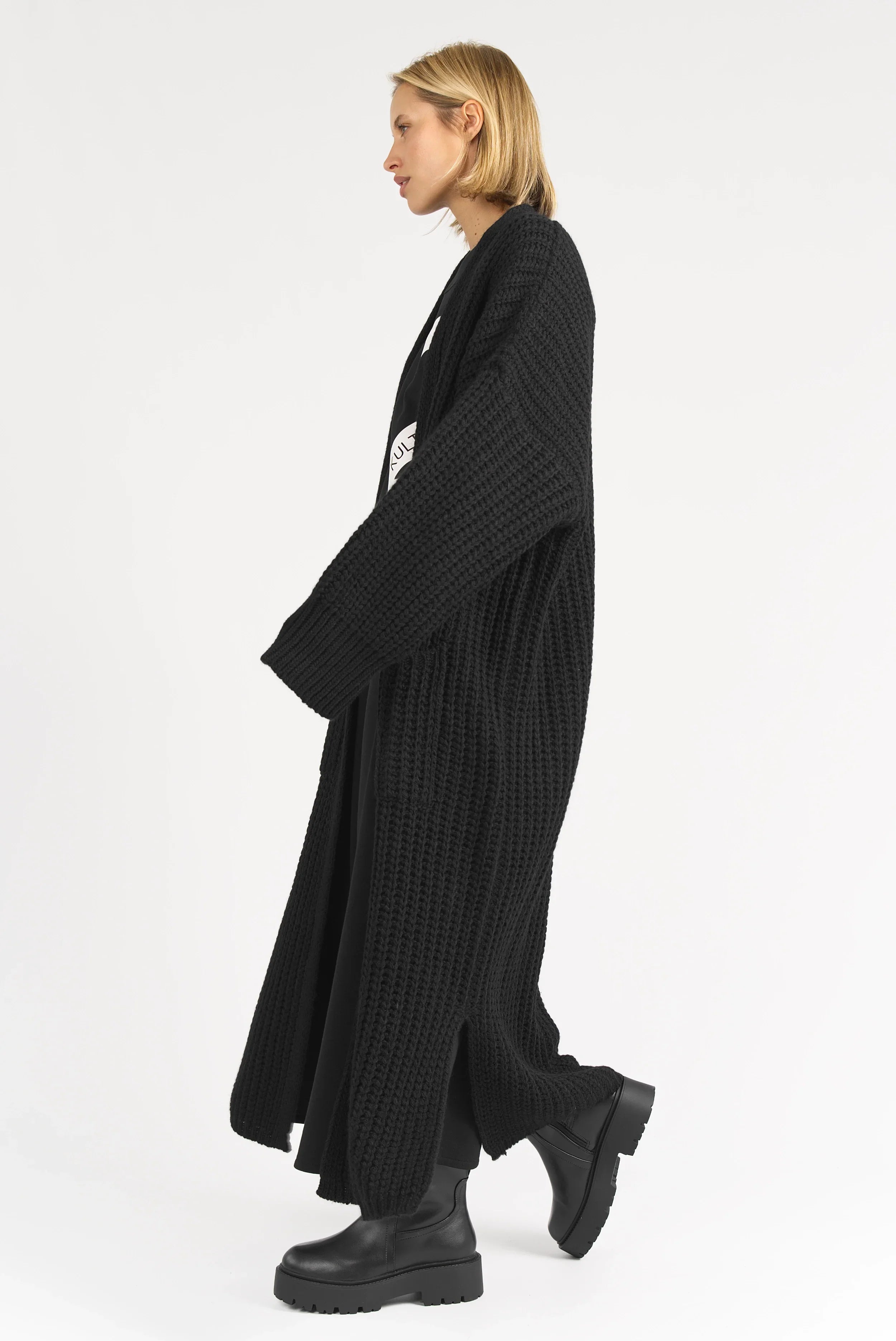 Frau trägt schwarzen LOLA Strickcardigan, oversized, locker und offen, mit aufgesetzten Taschen