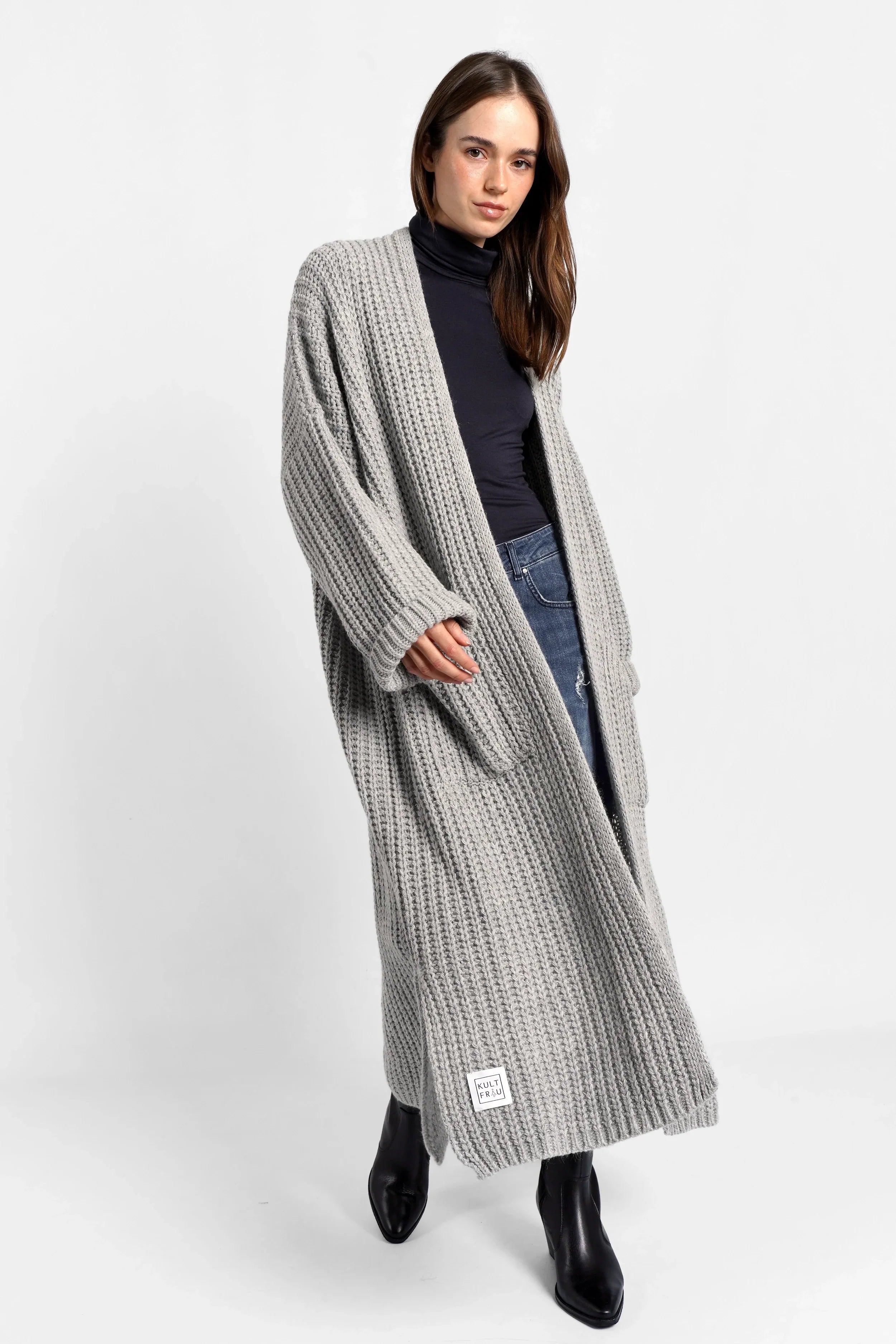 Frau trägt grauen LOLA Strickcardigan mit oversized Schnitt und aufgesetzten Taschen