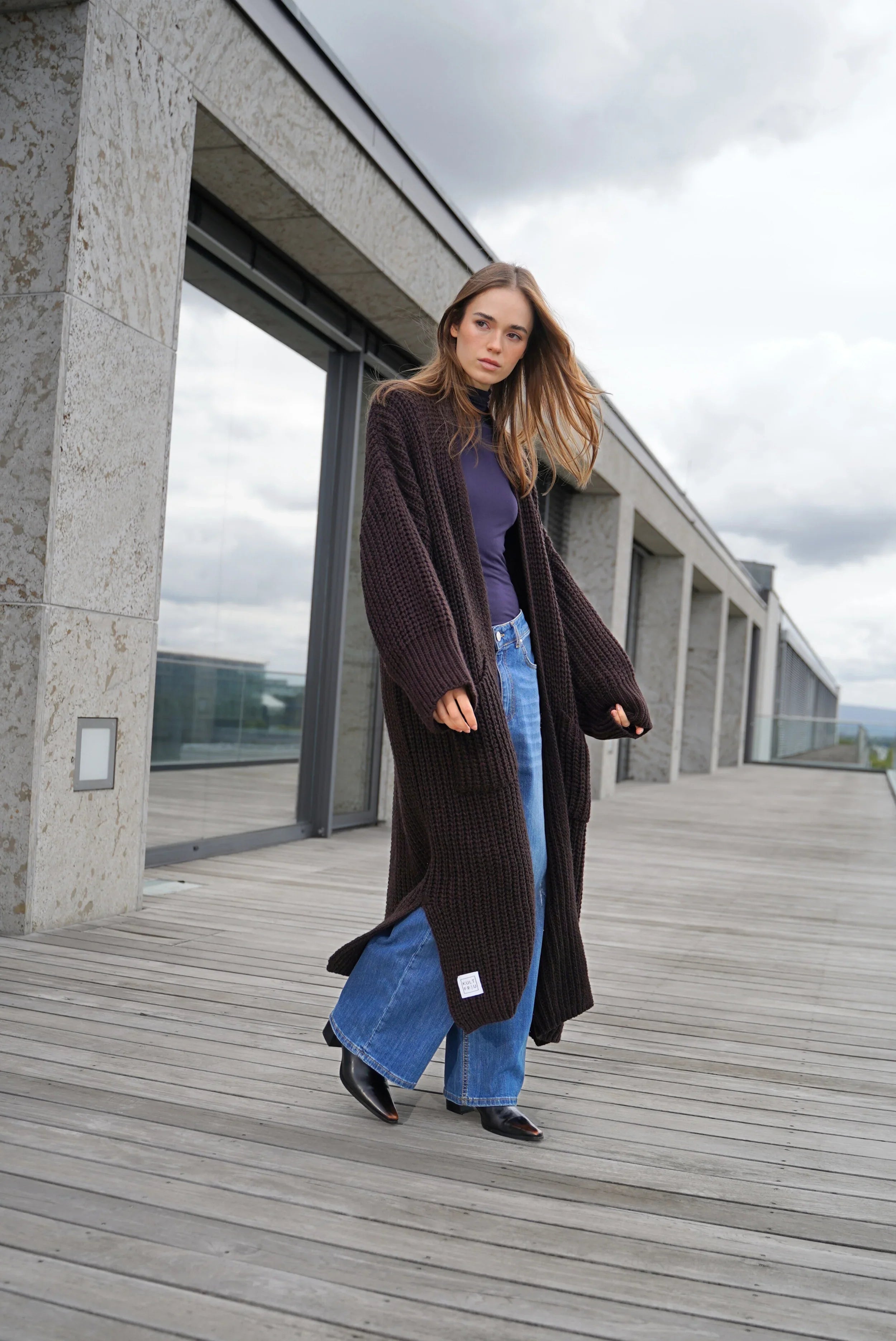 Woman wearing dark brown LOLA Strickcardigan open knit oversized cardigan with pockets and relaxed fit outdoors