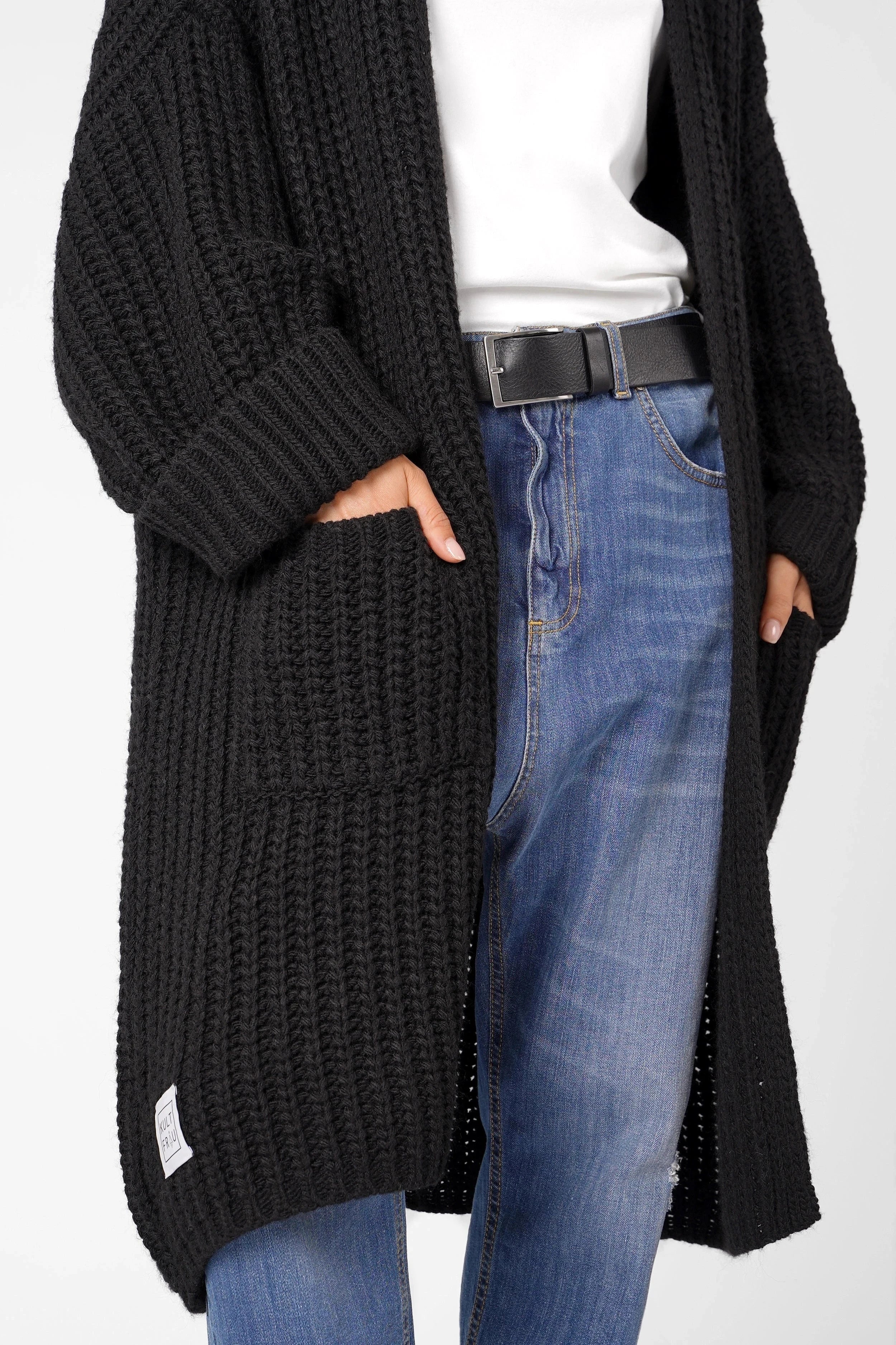 Oversized black Strickcardigan with open front and rolled sleeves worn with jeans and white top