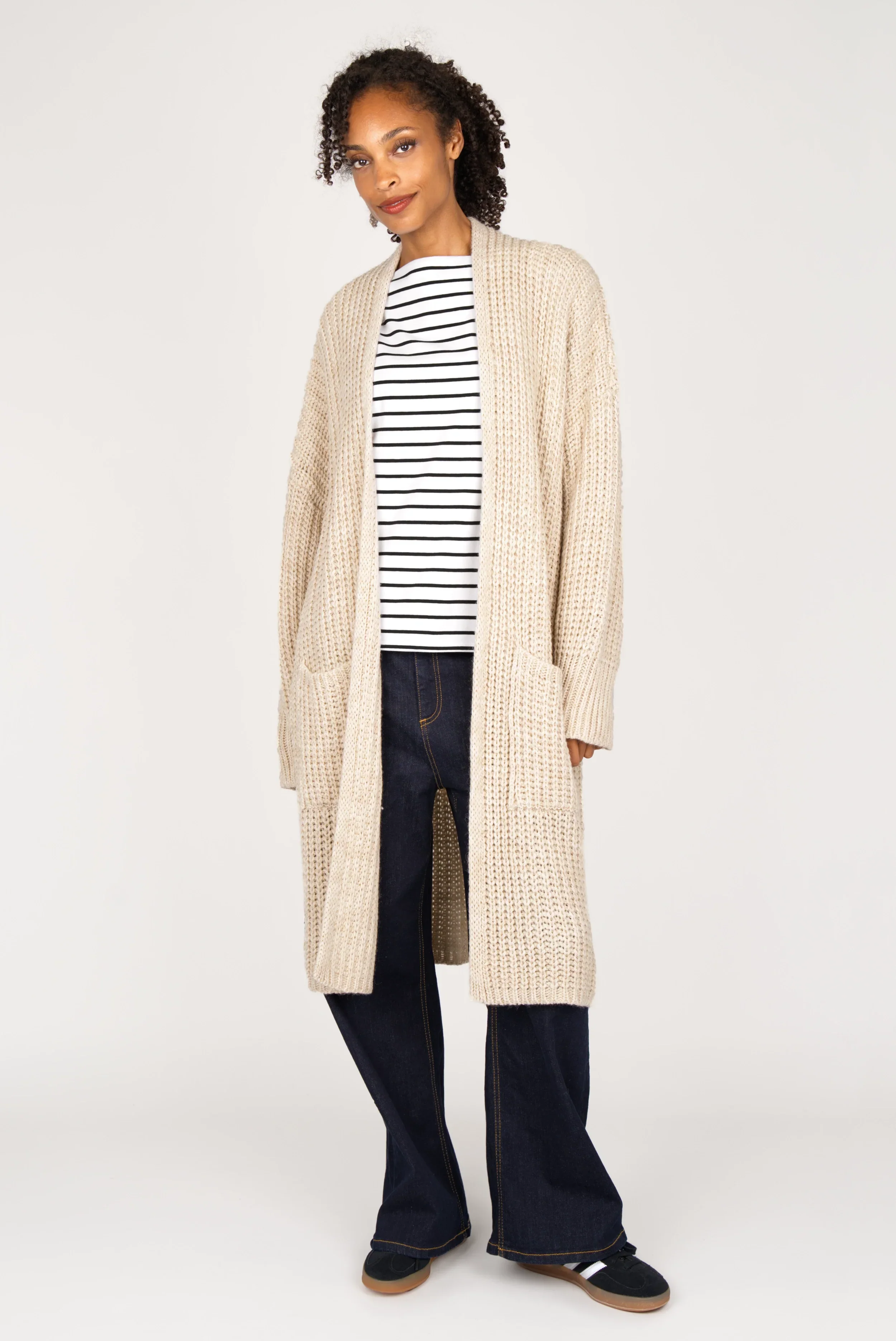 LOLYTA Strickcardigan oversized beige knitted cardigan with pockets worn open over striped shirt and dark jeans
