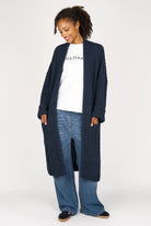 Oversized navy Strickcardigan with open front, relaxed fit, and rolled sleeves on woman.