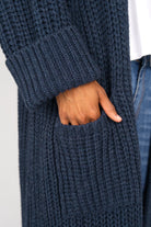 Detail of navy blue LOLLYTA oversized Strickcardigan pocket and cuff on model's hand