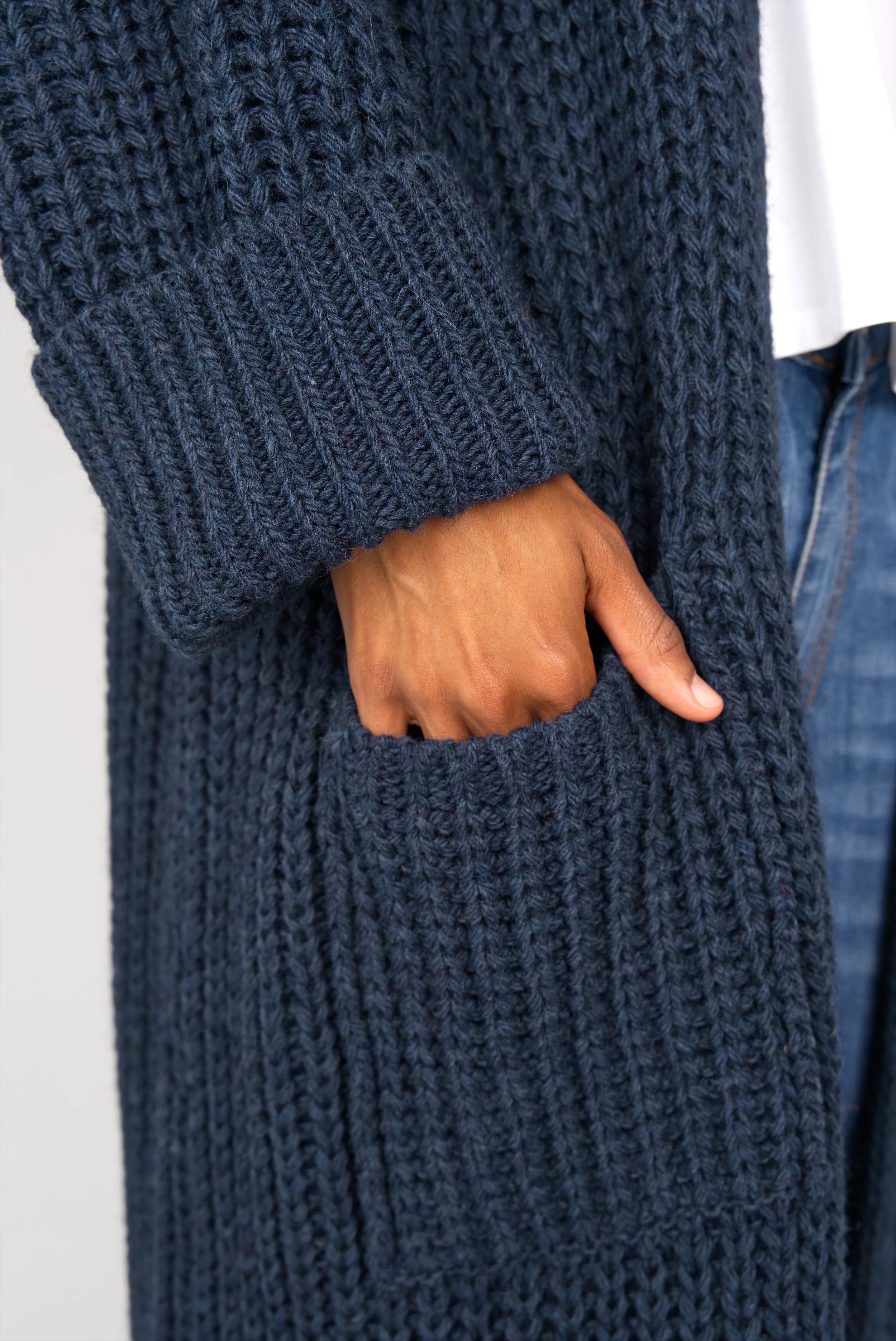 Detail of navy blue LOLLYTA oversized Strickcardigan pocket and cuff on model's hand