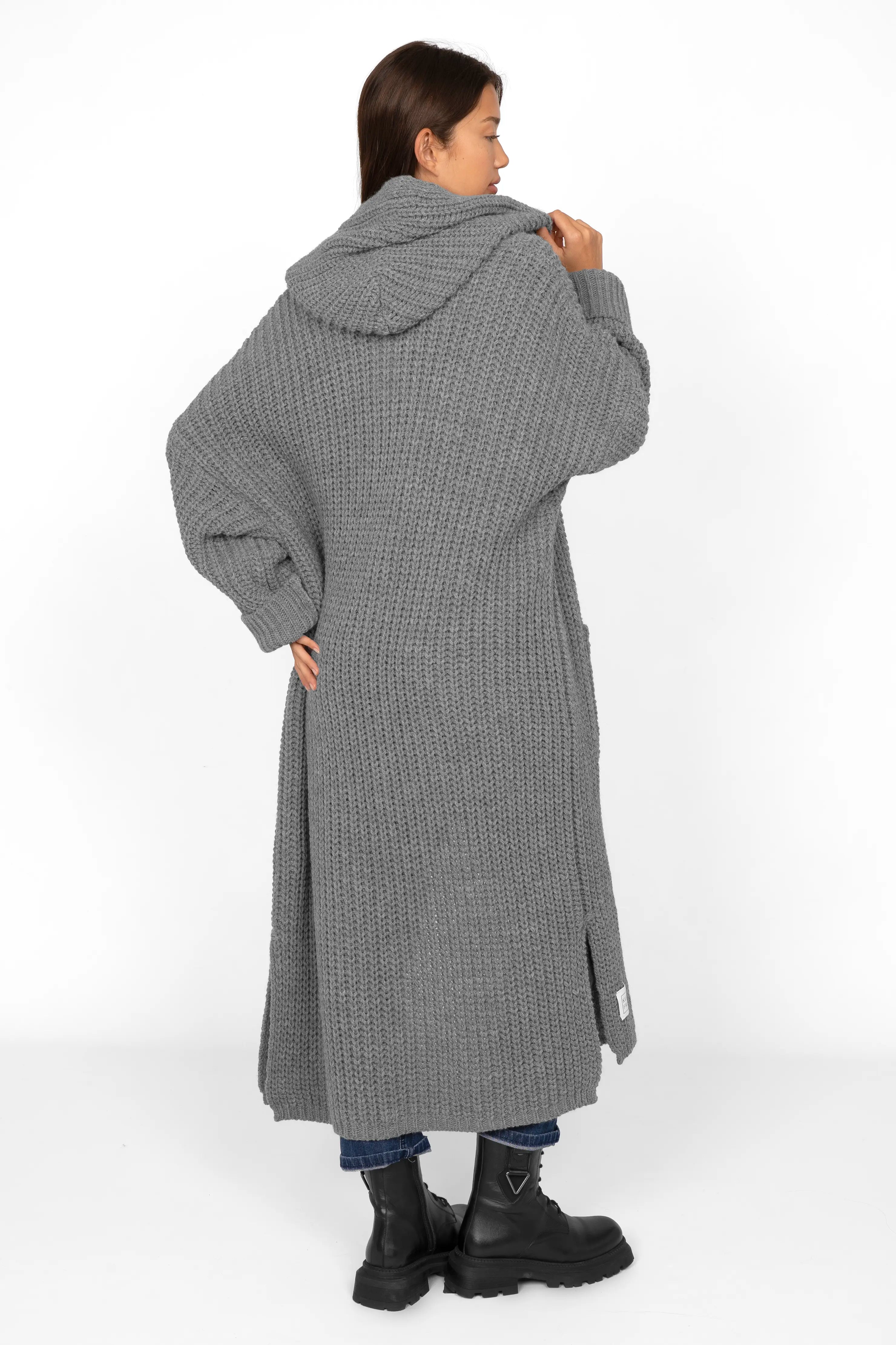 Frau trägt grauen LOVITA Long Cardigan mit Kapuze und aufgesetzten Taschen in Oversize-Passform.