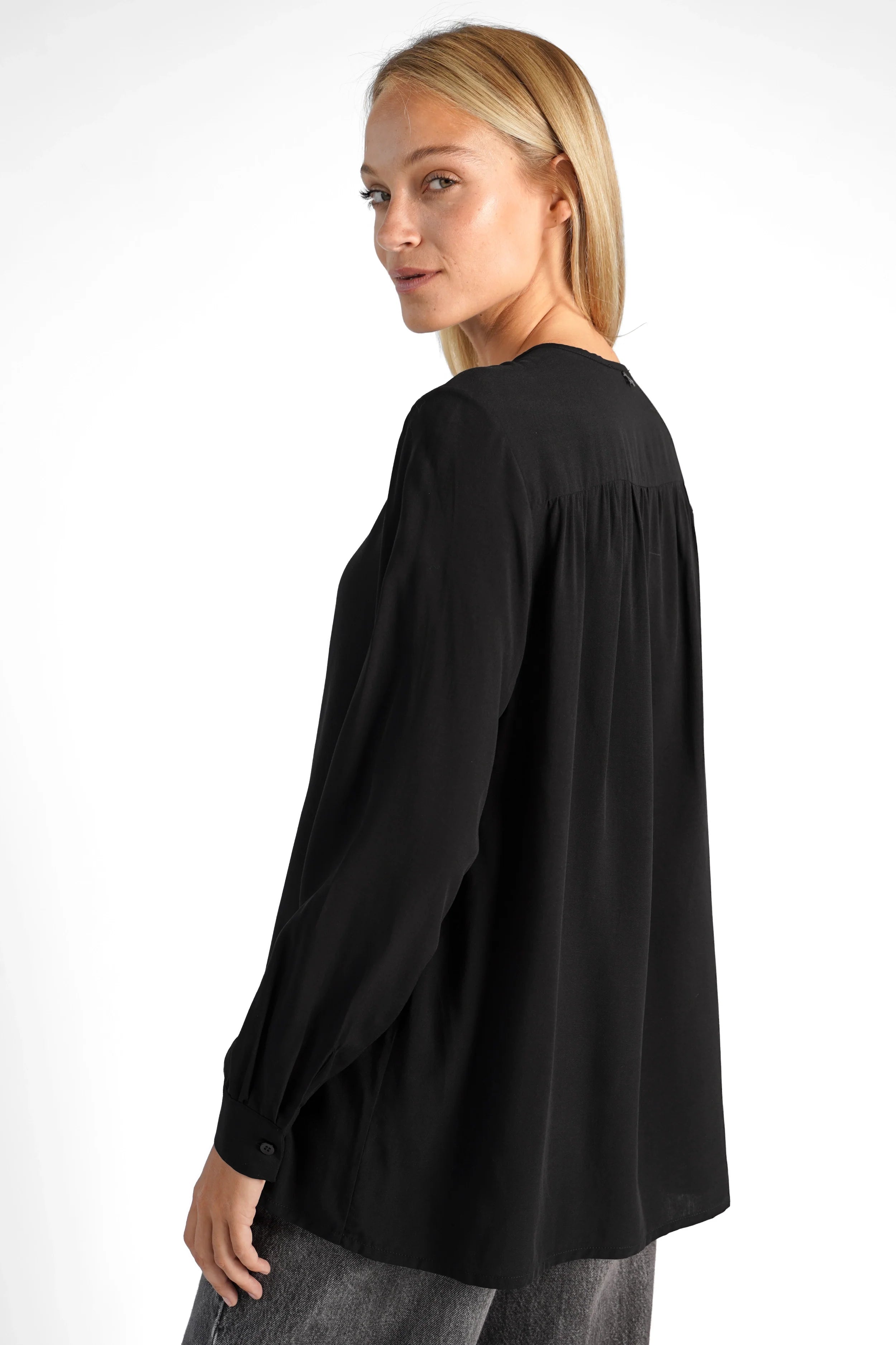 Woman wearing black LYLIA.K Loose Fit Bluse with soft Viscose fabric and pleated details on back and sleeves