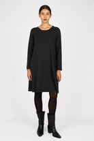Black A-Linie Kleid with long sleeves, round neckline, and regular fit worn with black tights and boots