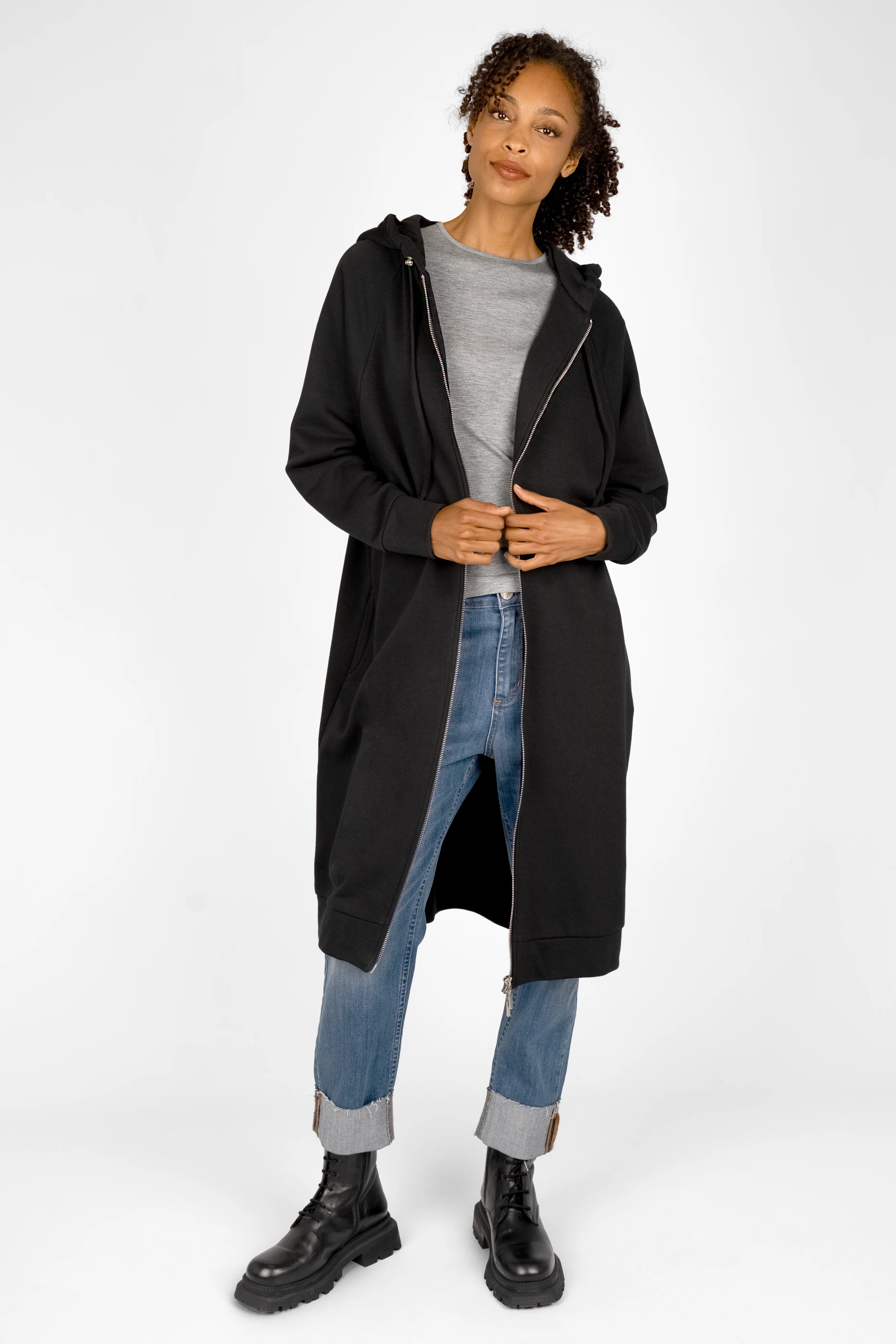 Woman wearing black MANDI.K Longzip-Hoodie with two-way zipper, large hood, and side pockets