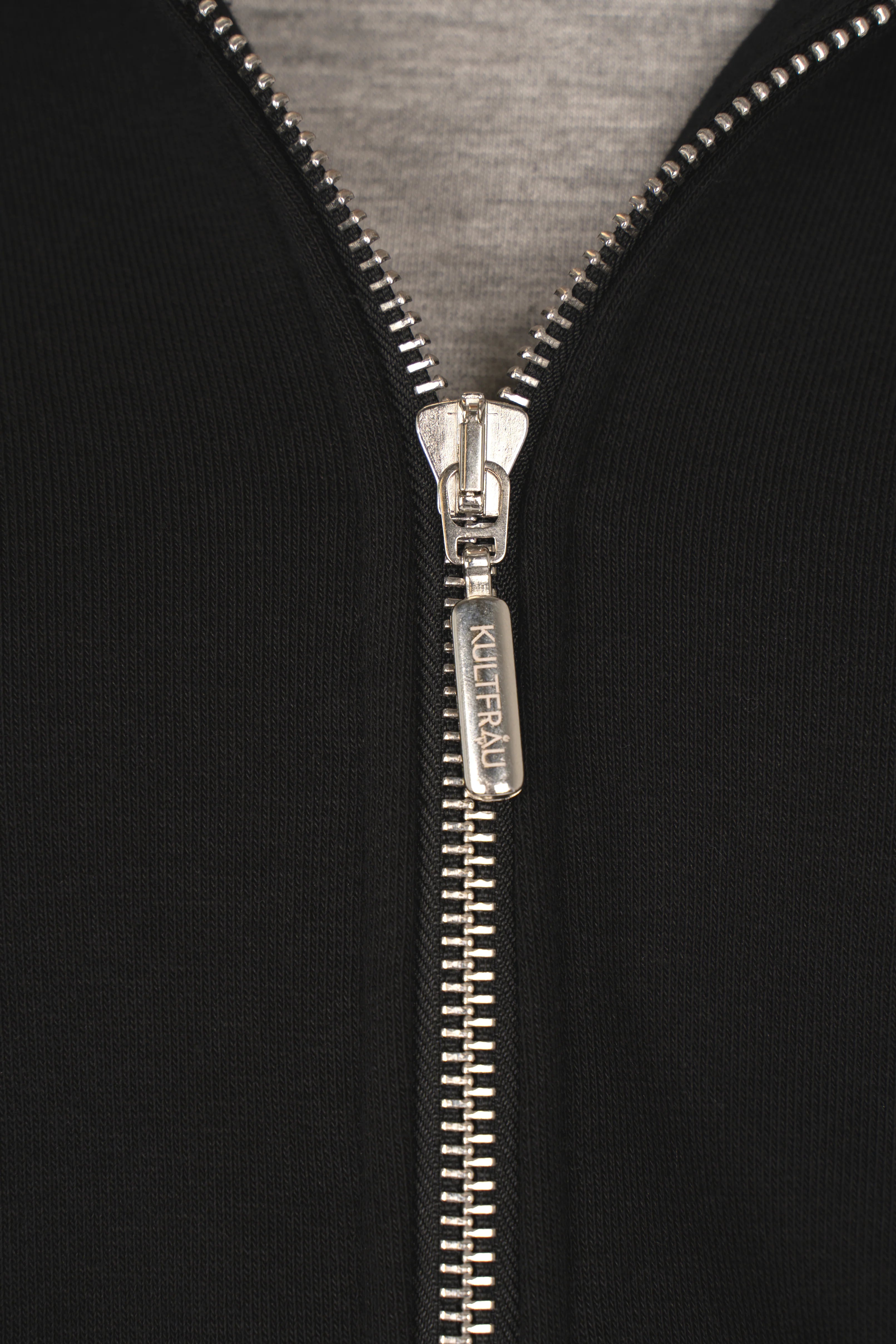 Close-up of black MANDI.K Longzip-Hoodie with silver two-way zipper and grey inner lining