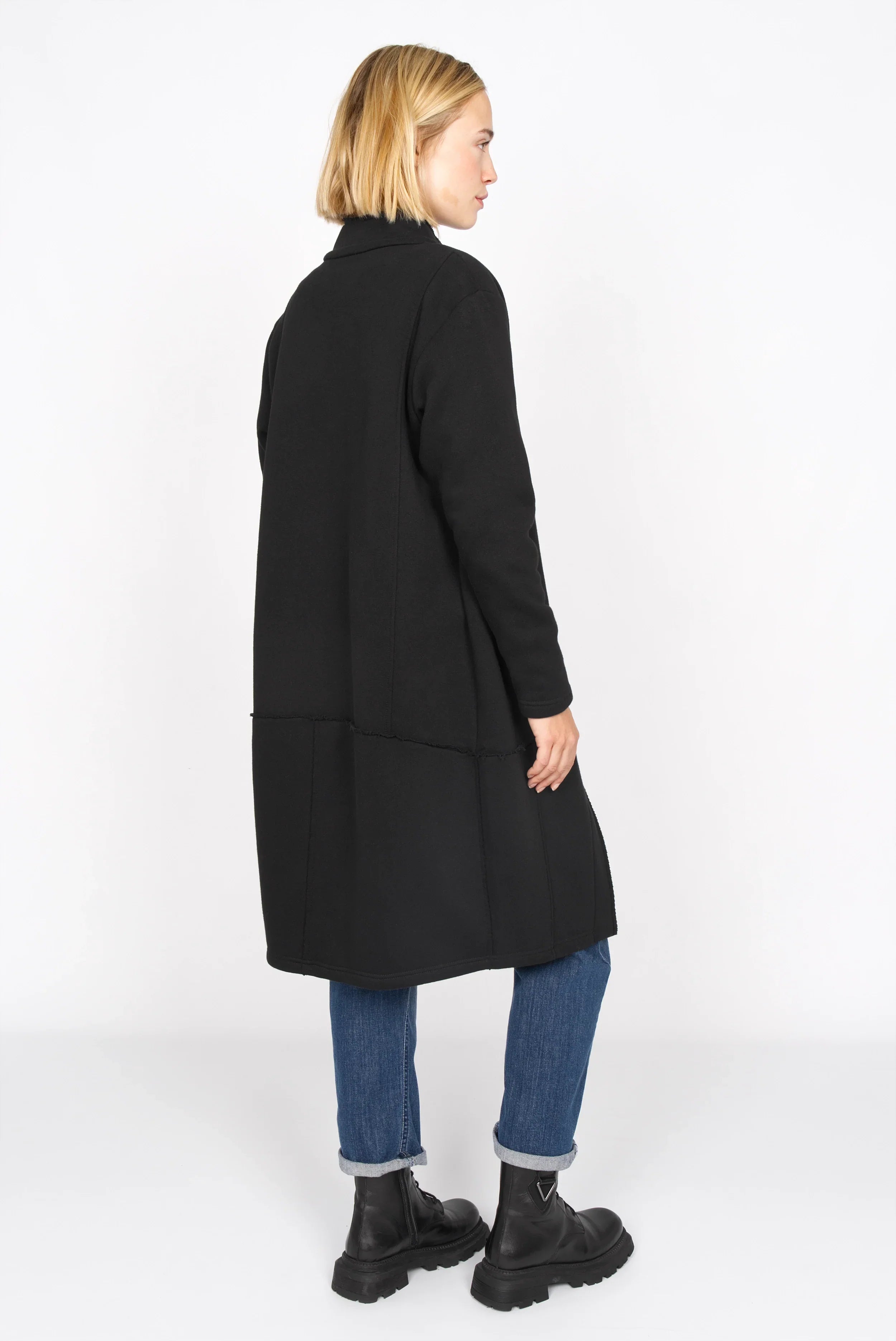 Frau trägt schwarzen MANEY Sweatmantel mit verdeckter Knopfleiste und offenkantigem Design hinten länger