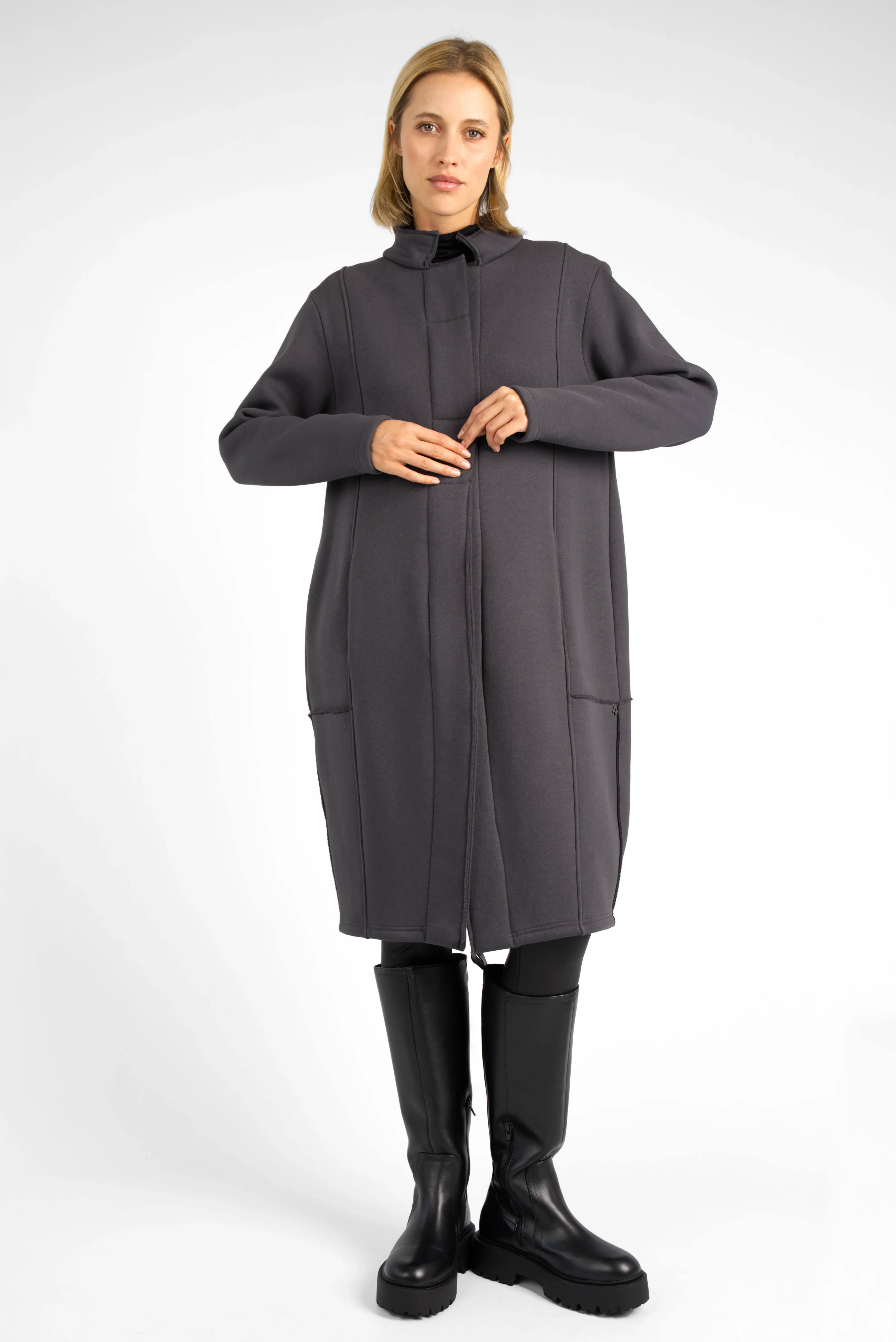 Woman wearing a dark grey MANEY Sweatmantel with concealed button placket and balloon silhouette