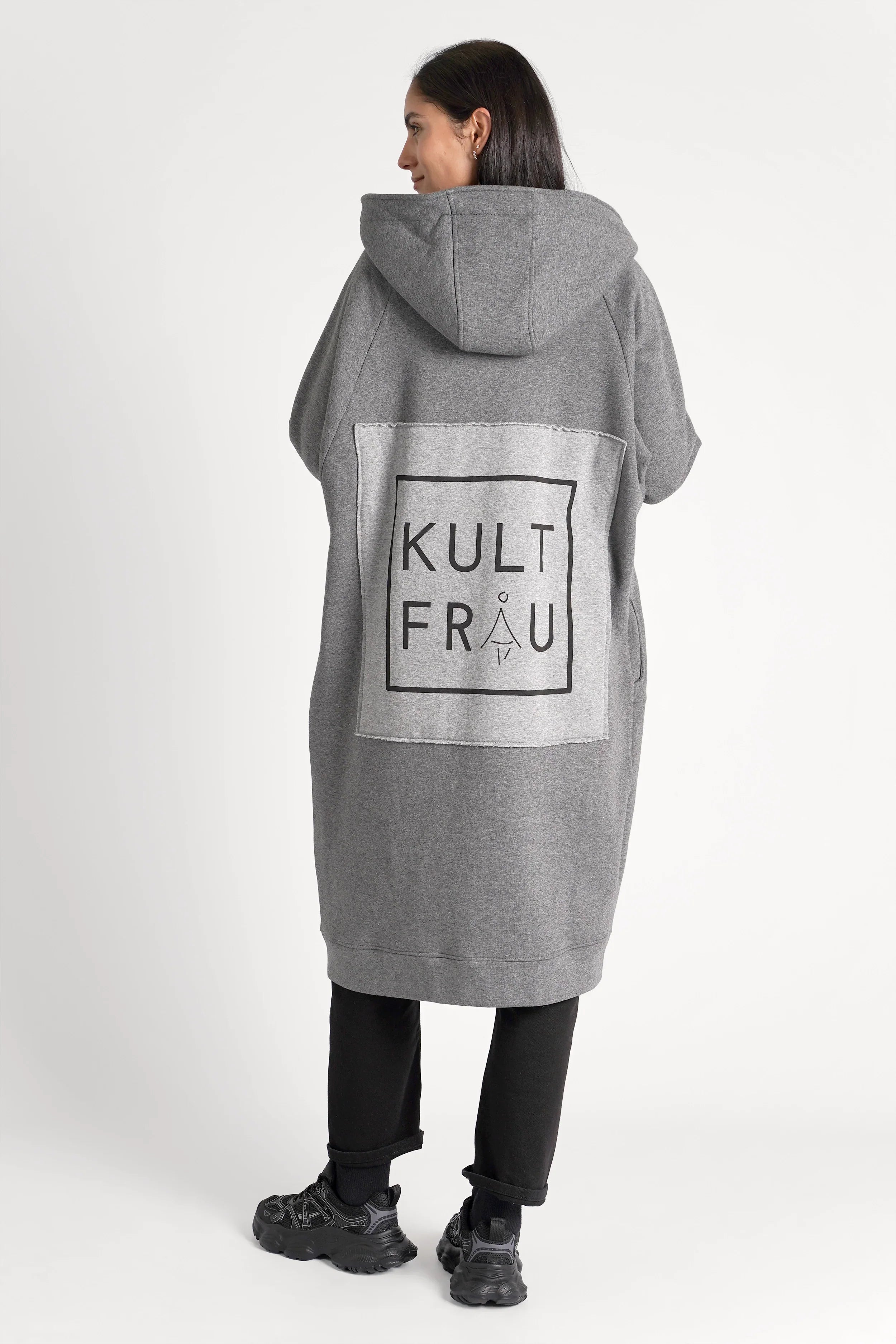 Woman wearing gray oversized MAY Longzip-Hoodie with hood and large logo patch on the back