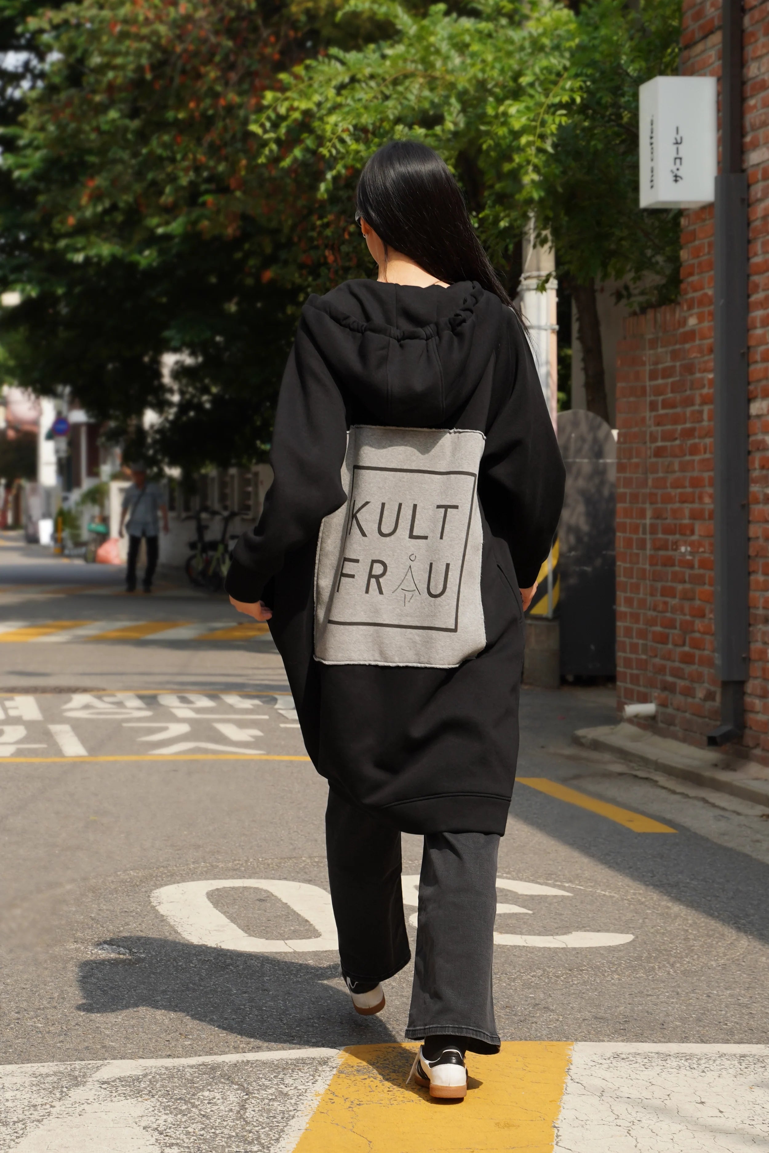 Black oversized MAY Longzip-Hoodie with hoodie, two-way zipper, side pockets, and large back logo patch with raw edges