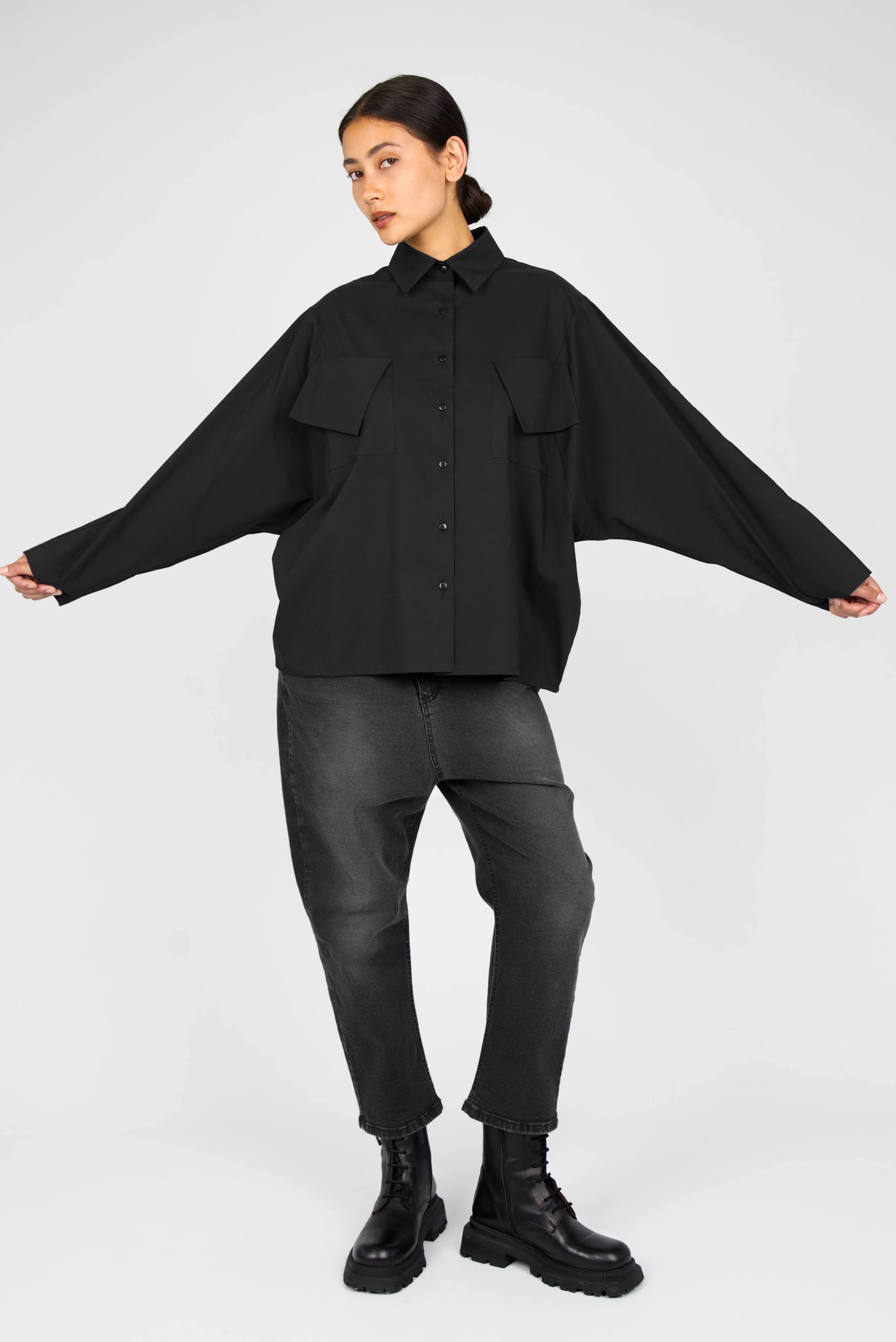 Black MELIZA Bluse with relaxed fit, bat-cut sleeves, asymmetrical flap pockets, and button-down front in modern popeline fabric.