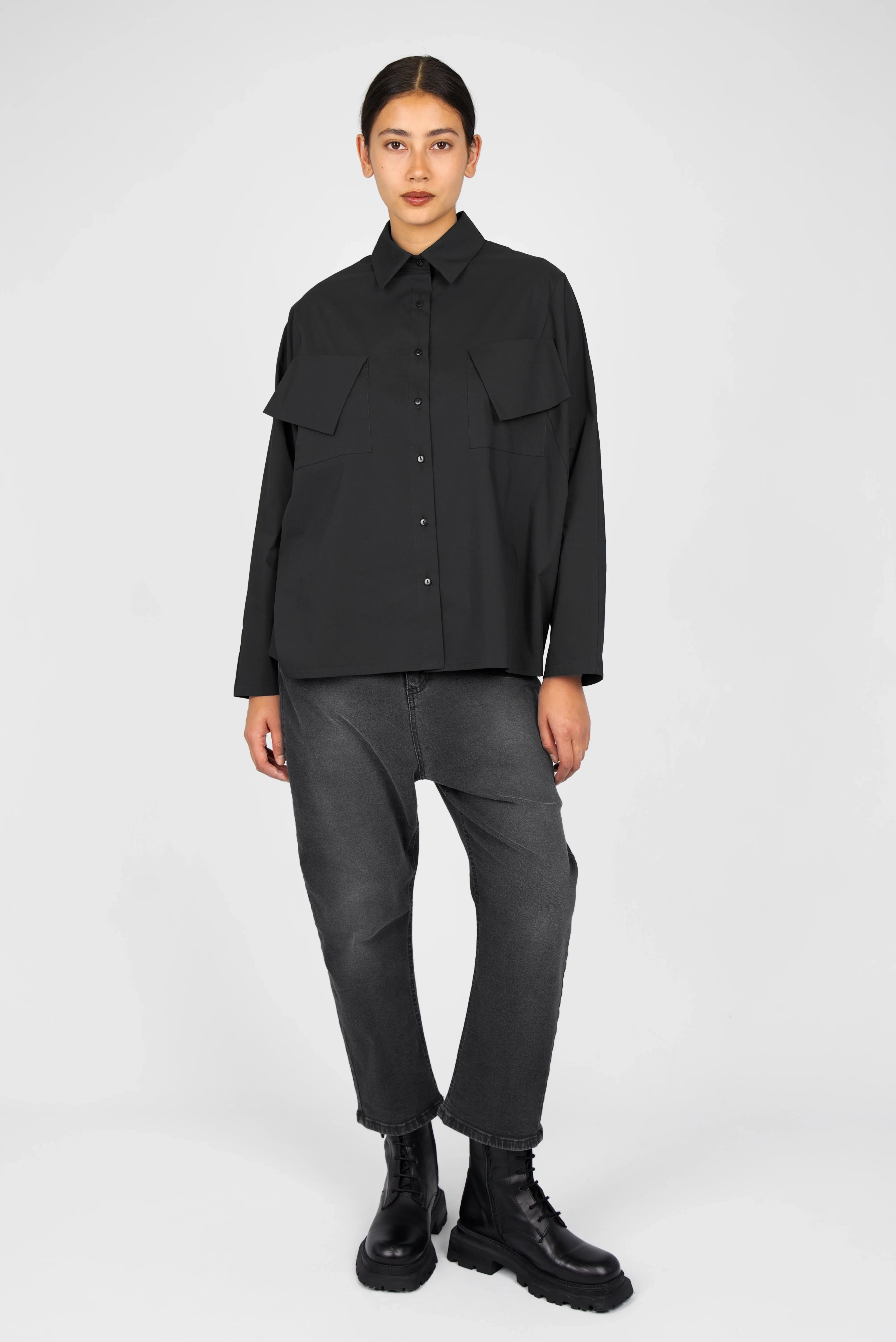 Woman wearing MELIZA Bluse black loose-fit popeline shirt with bat-cut sleeves and asymmetrical flap pockets