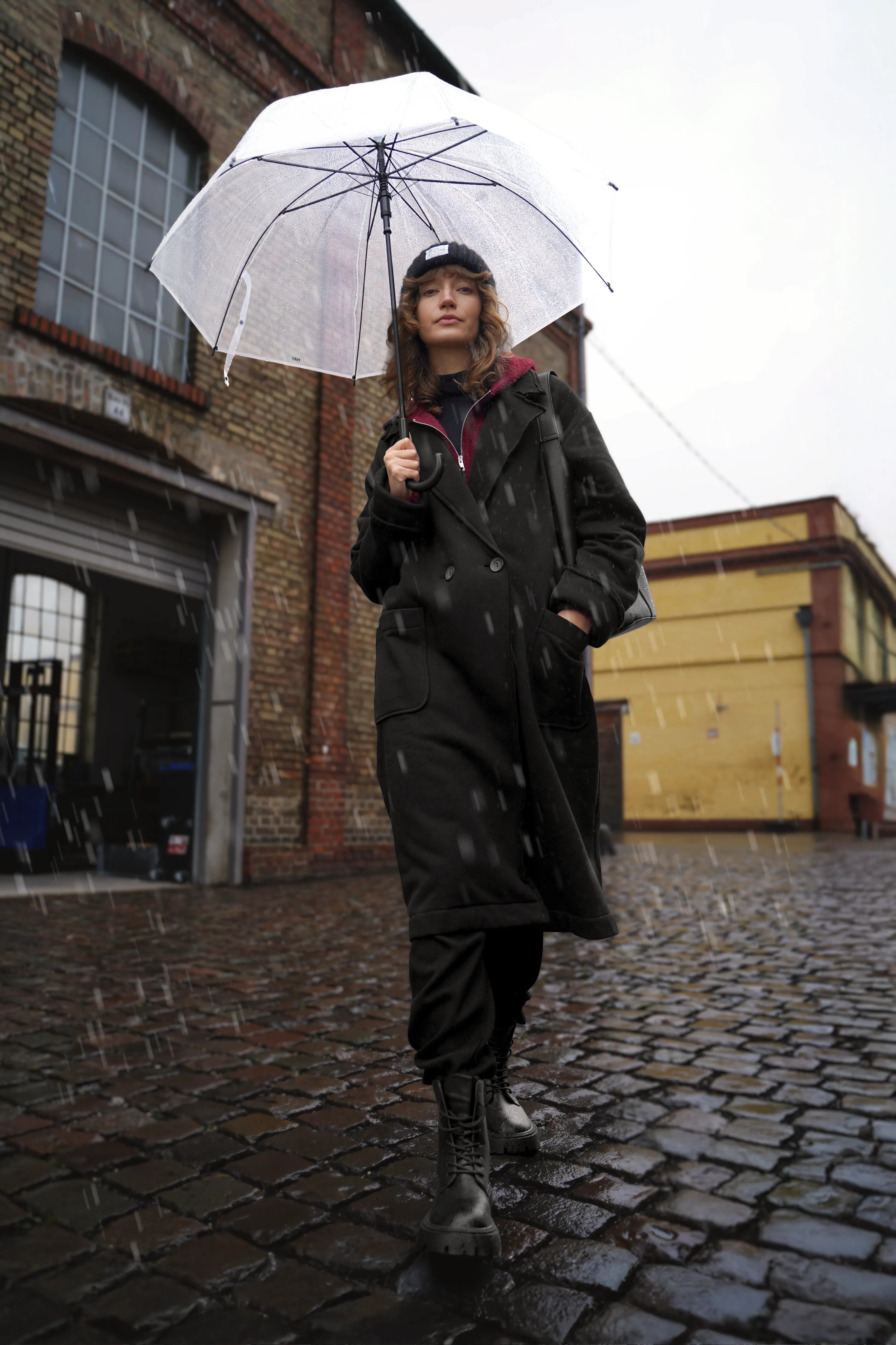 Frau trägt MONDY.K Oversize Sweatmantel mit Reverskragen, großen Taschen und umschlagbaren Ärmeln bei Regen