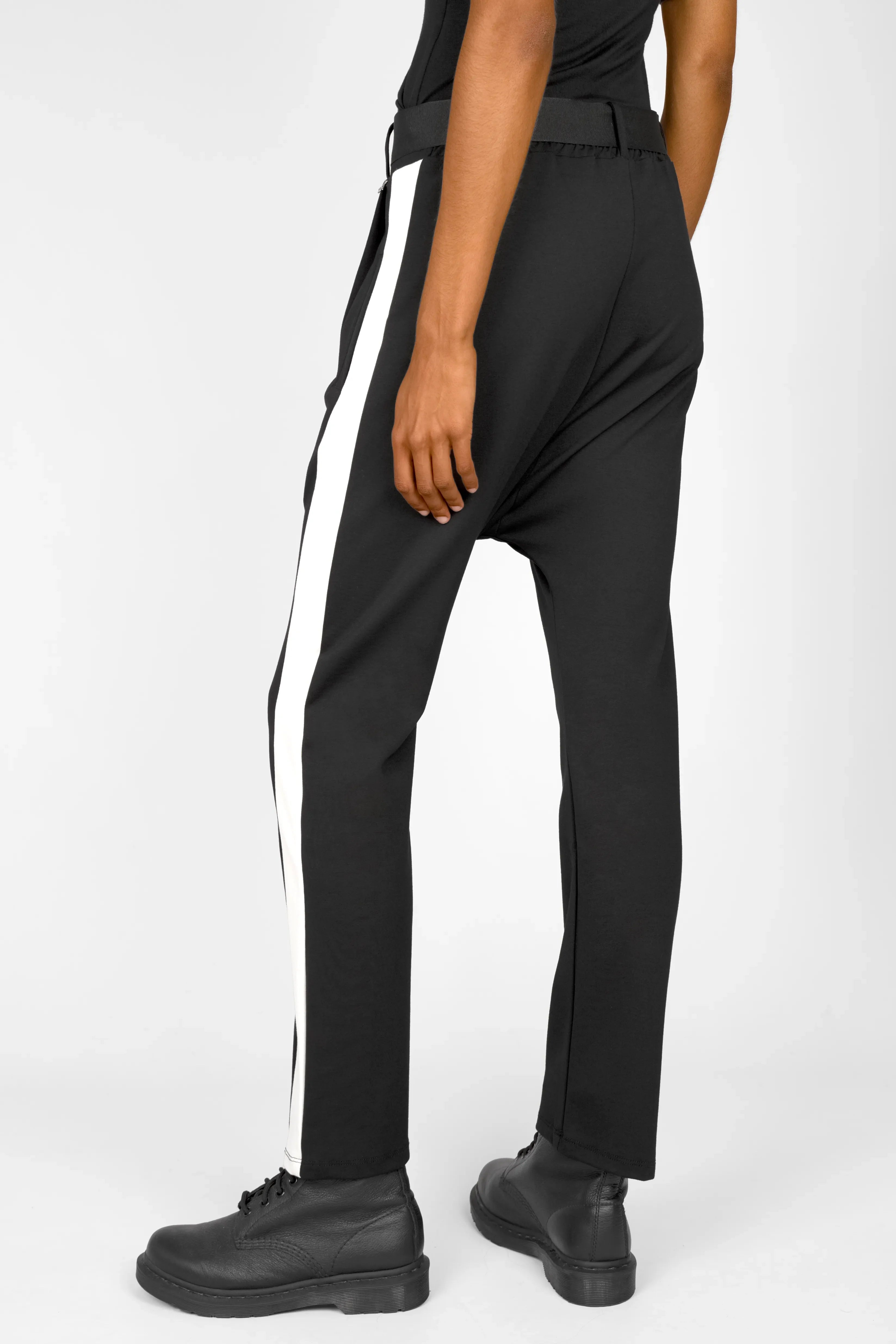 Black MYRAN Tapered Sweathose with white contrast stripes and adjustable belt worn by model, showing deep crotch and tapered leg design