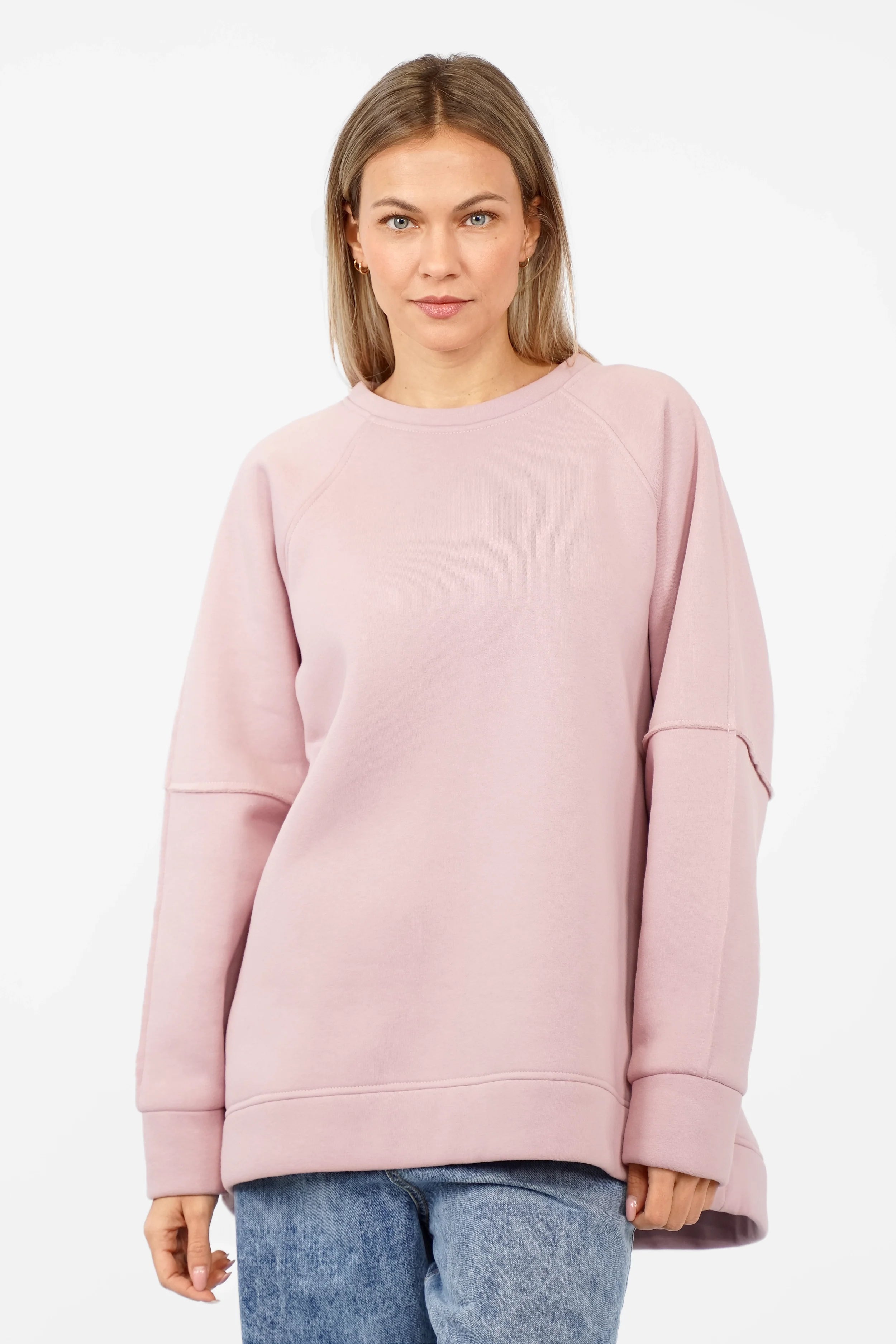 Woman wearing pink NAIRA Cozy Sweater with A-line silhouette and brushed cotton interior