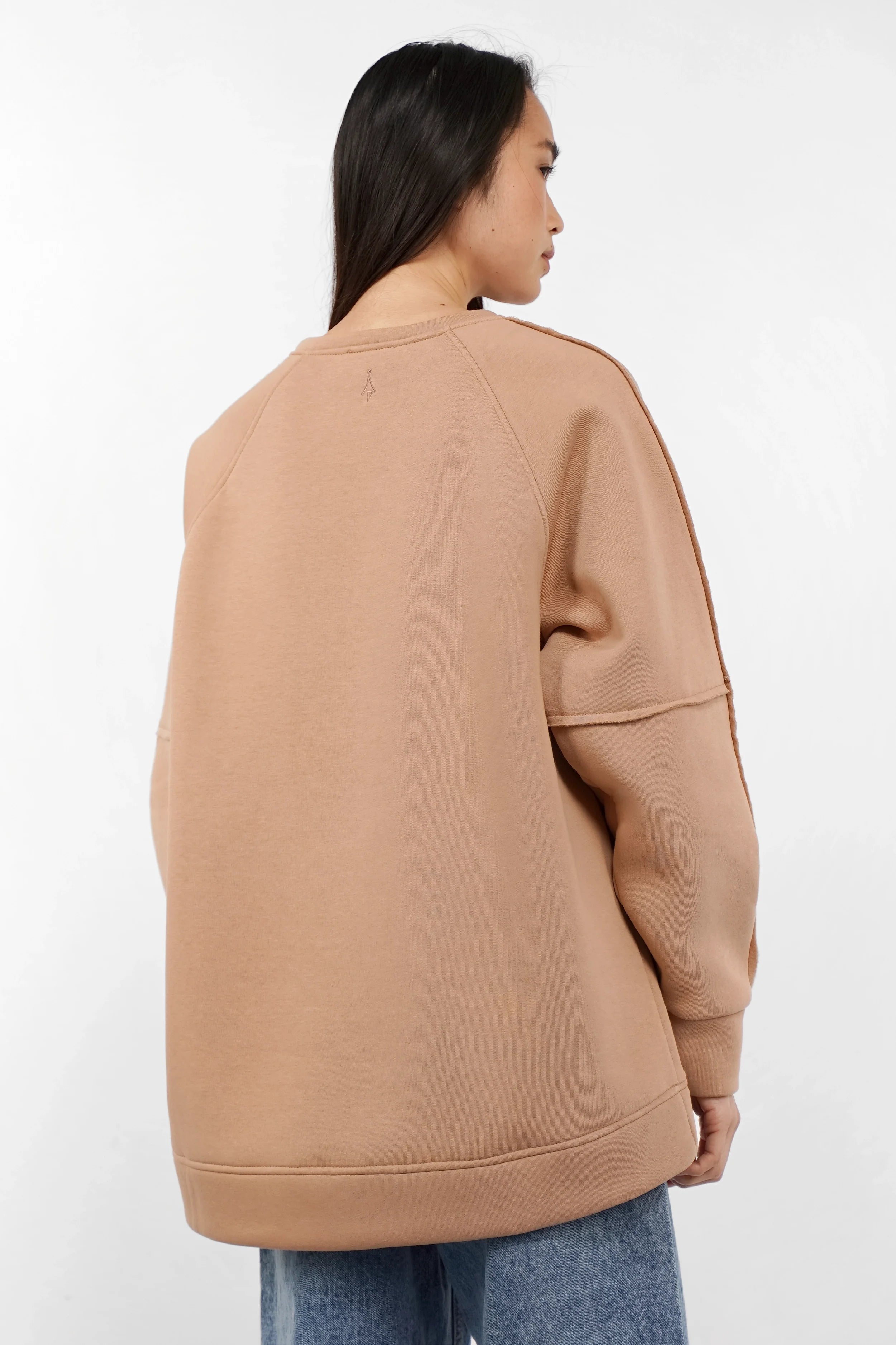 NAIRA Cozy Sweater in beige with brushed soft cotton, A-line silhouette, raglan sleeves, and rounded hem seen from back